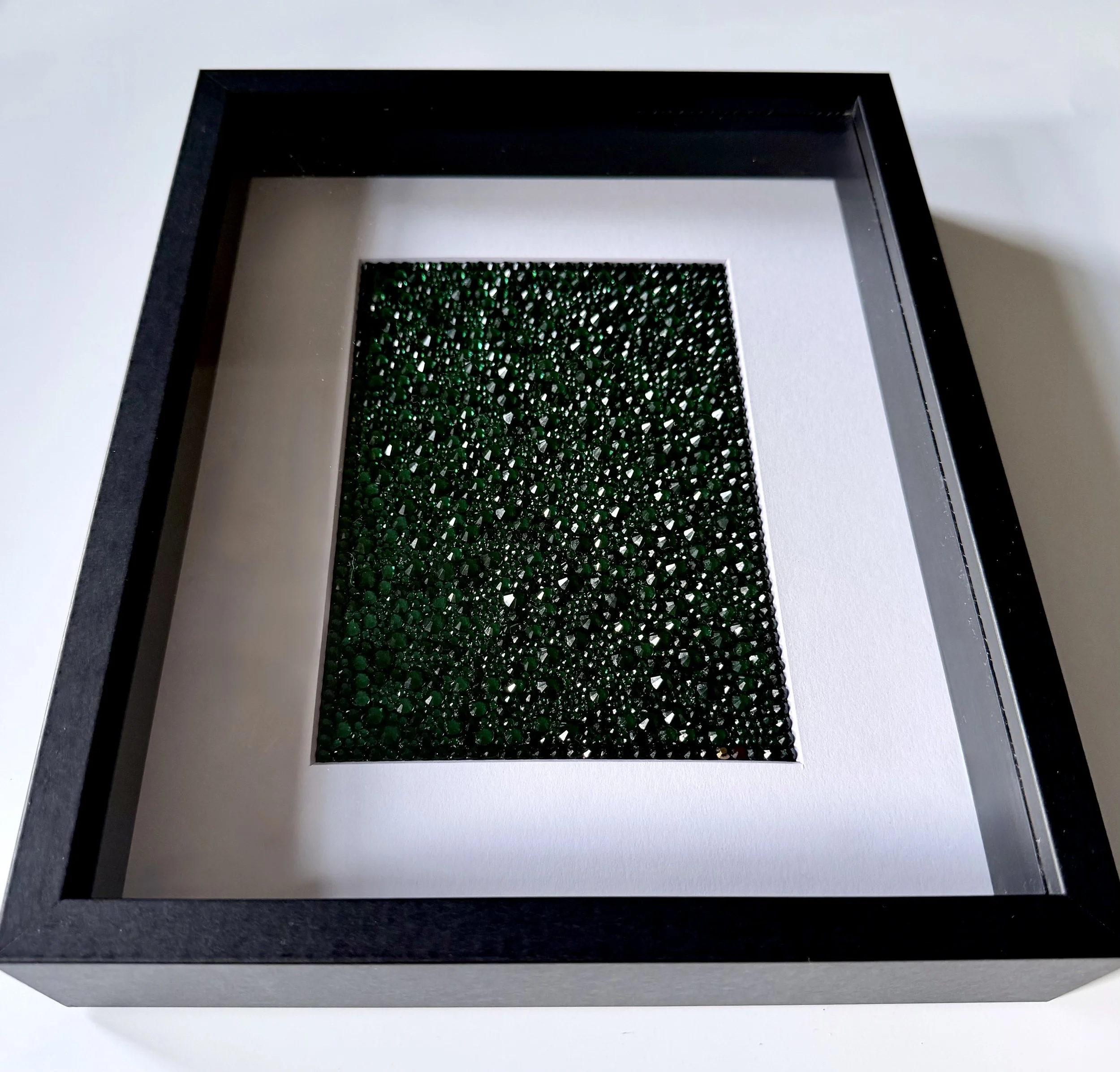 Framed emerald rhinestone art piece titled "Continuum."