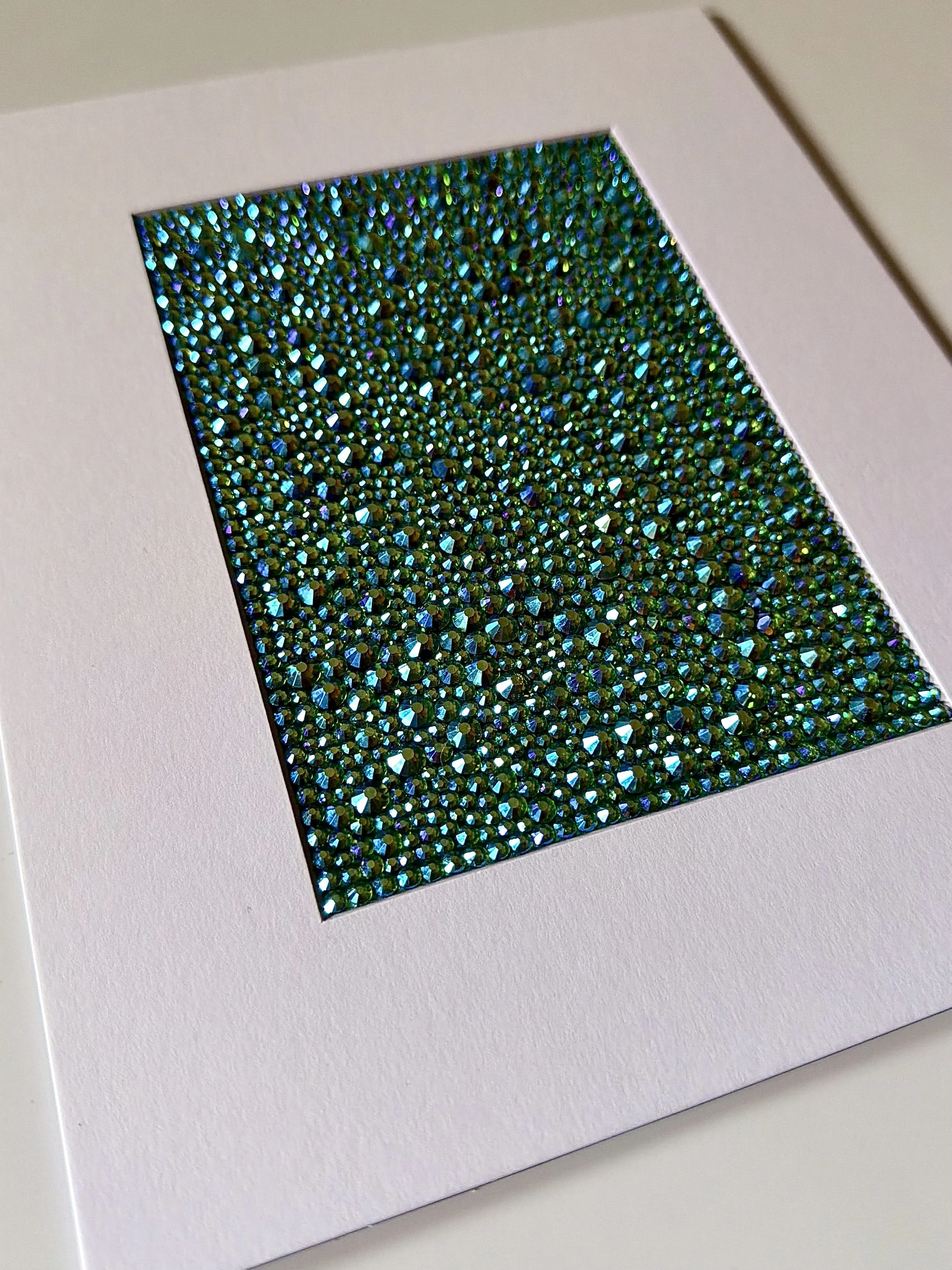 An angled close-up of the "Vacant" paper study, showing the high-relief texture of the green and gold rhinestone field.