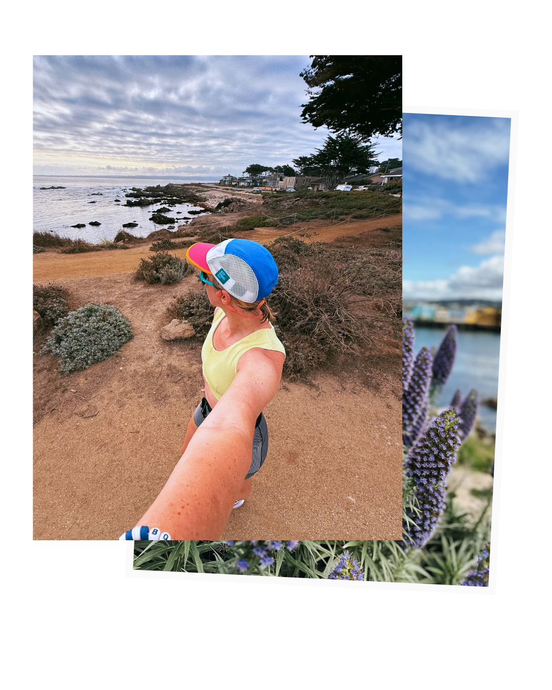A woman in a yellow tank top, gray shorts, and a colorful blue, white, and pink cap taking a selfie along a rocky coastline with the ocean and houses in the background.