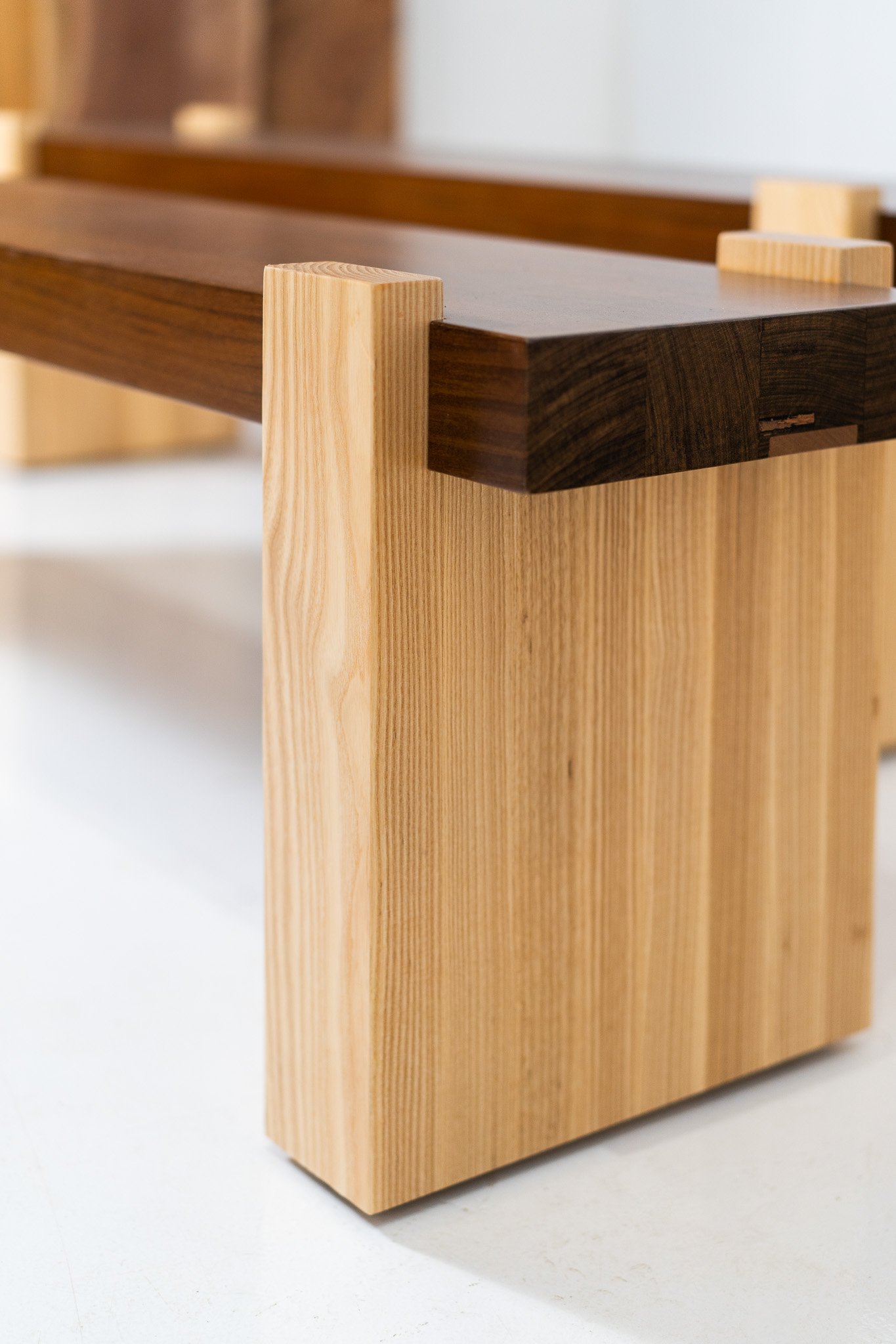 Close-up of a modern wooden table with light and dark wood contrasting in a minimalist design.