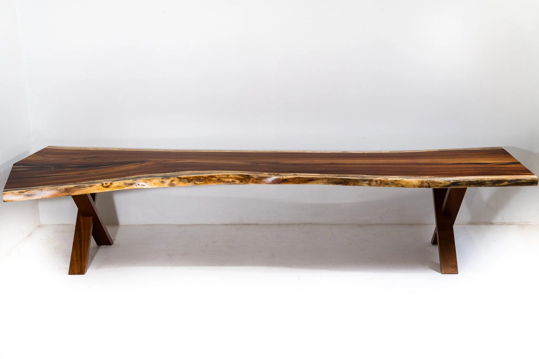A wooden bench with a polished natural finish, placed against a white background.