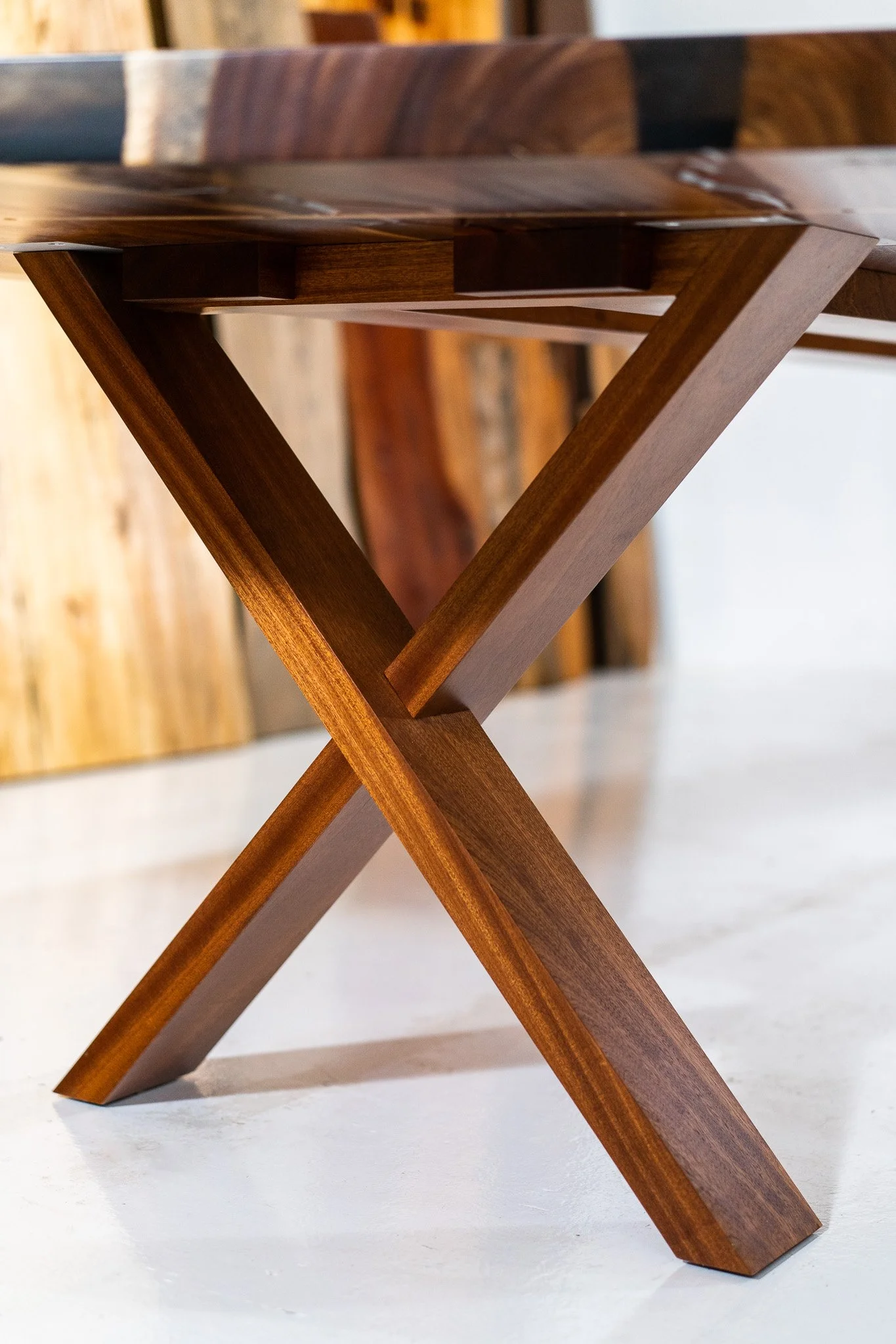 Close-up of a wooden table with an intersecting leg design.