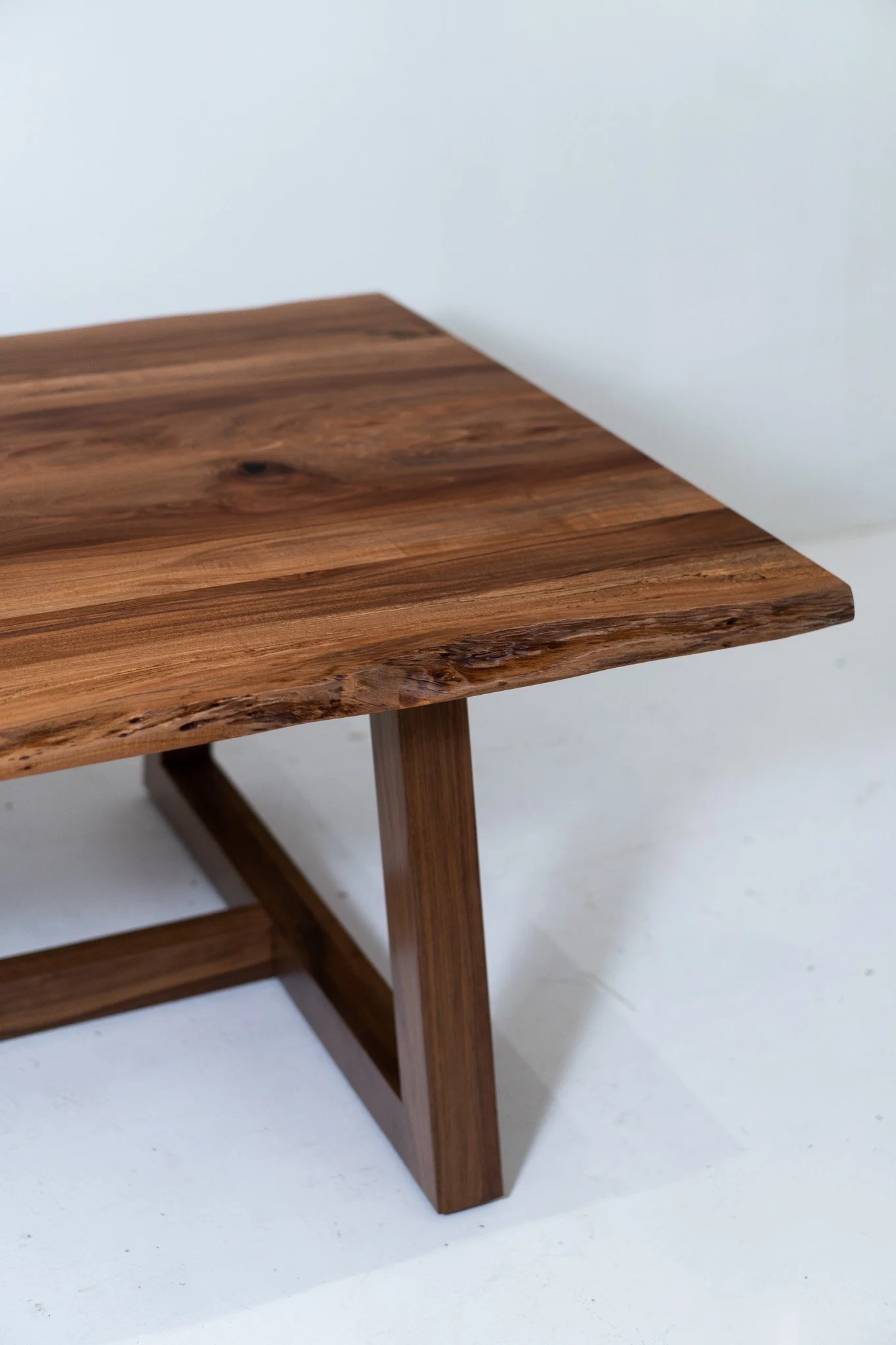Close-up of a wooden table with natural wood grain, against a plain white background.