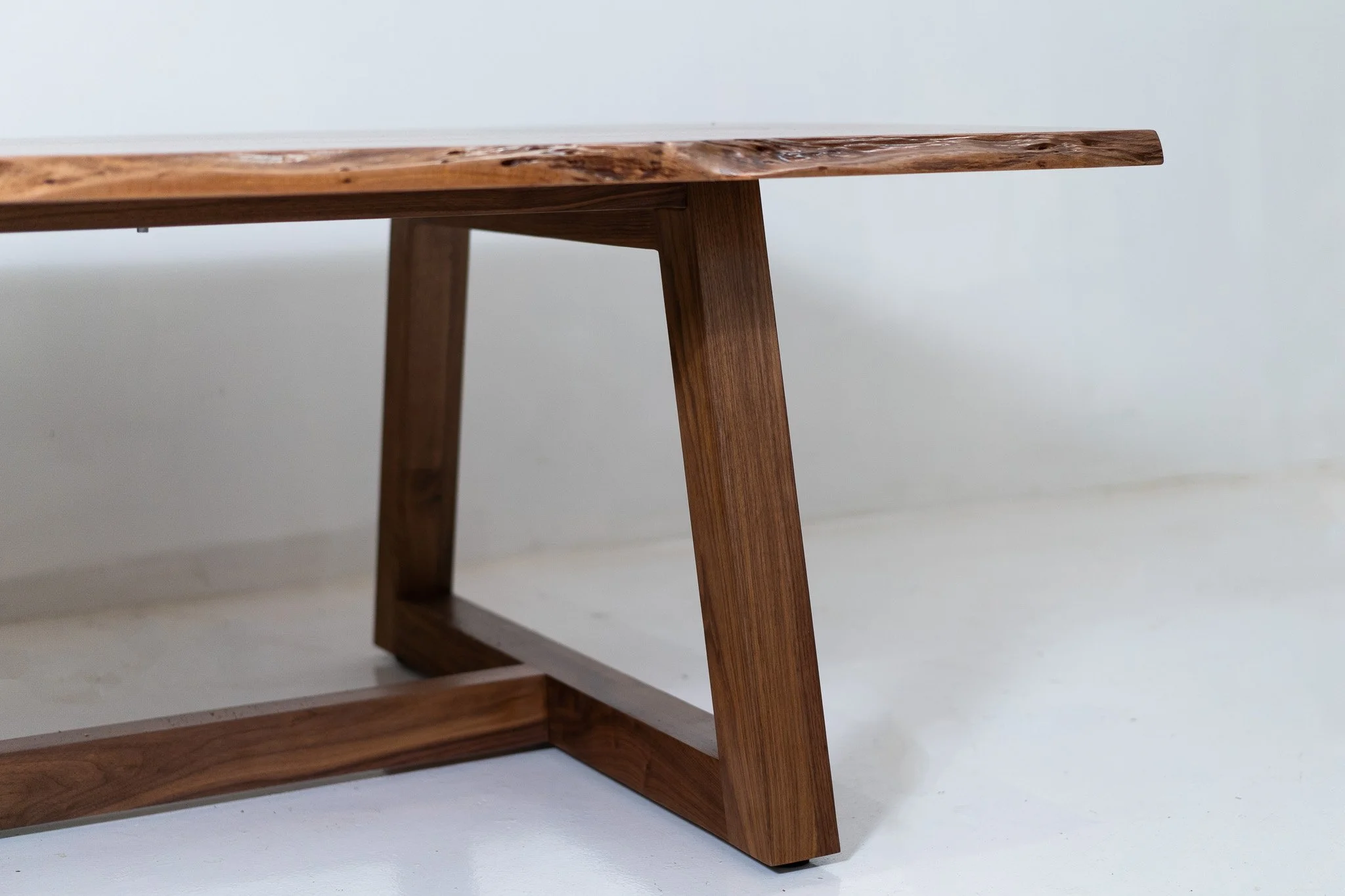 Close-up of a wooden table with a light-colored wall in the background.