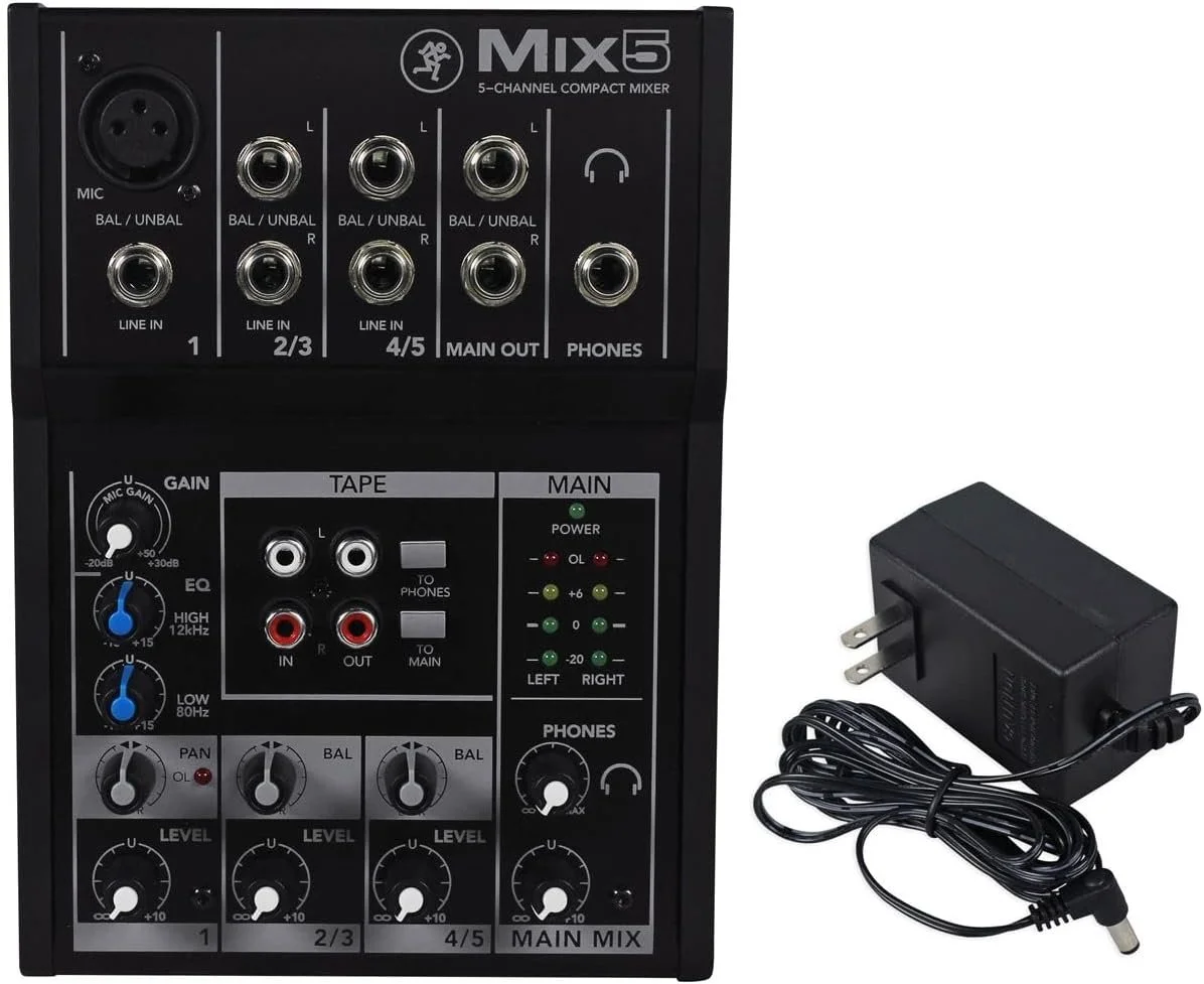 Audio mixer with multiple input ports, knobs, and controls, accompanied by a power adapter.