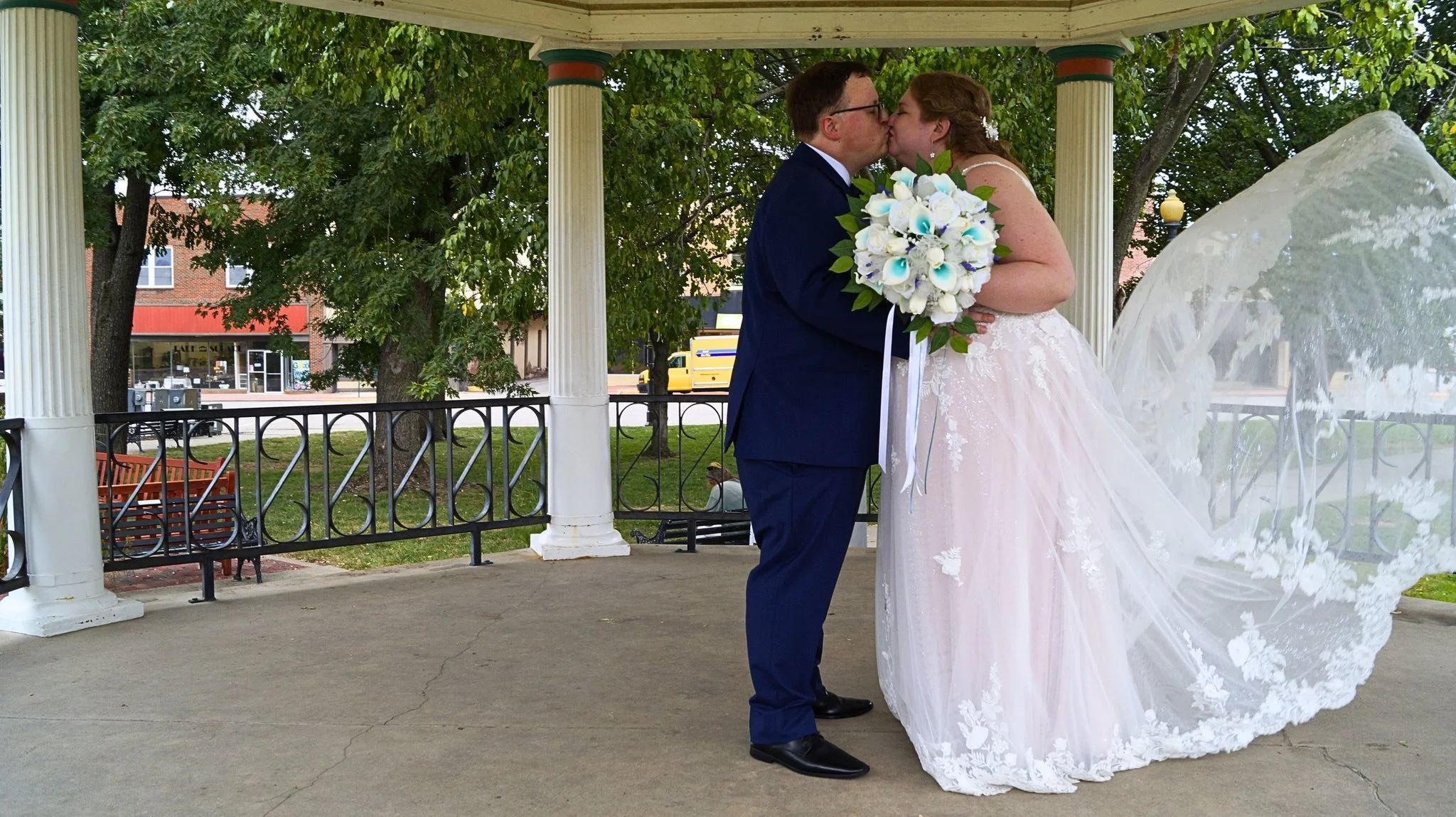 bride-groom-kiss-bouquet-flowing-dress