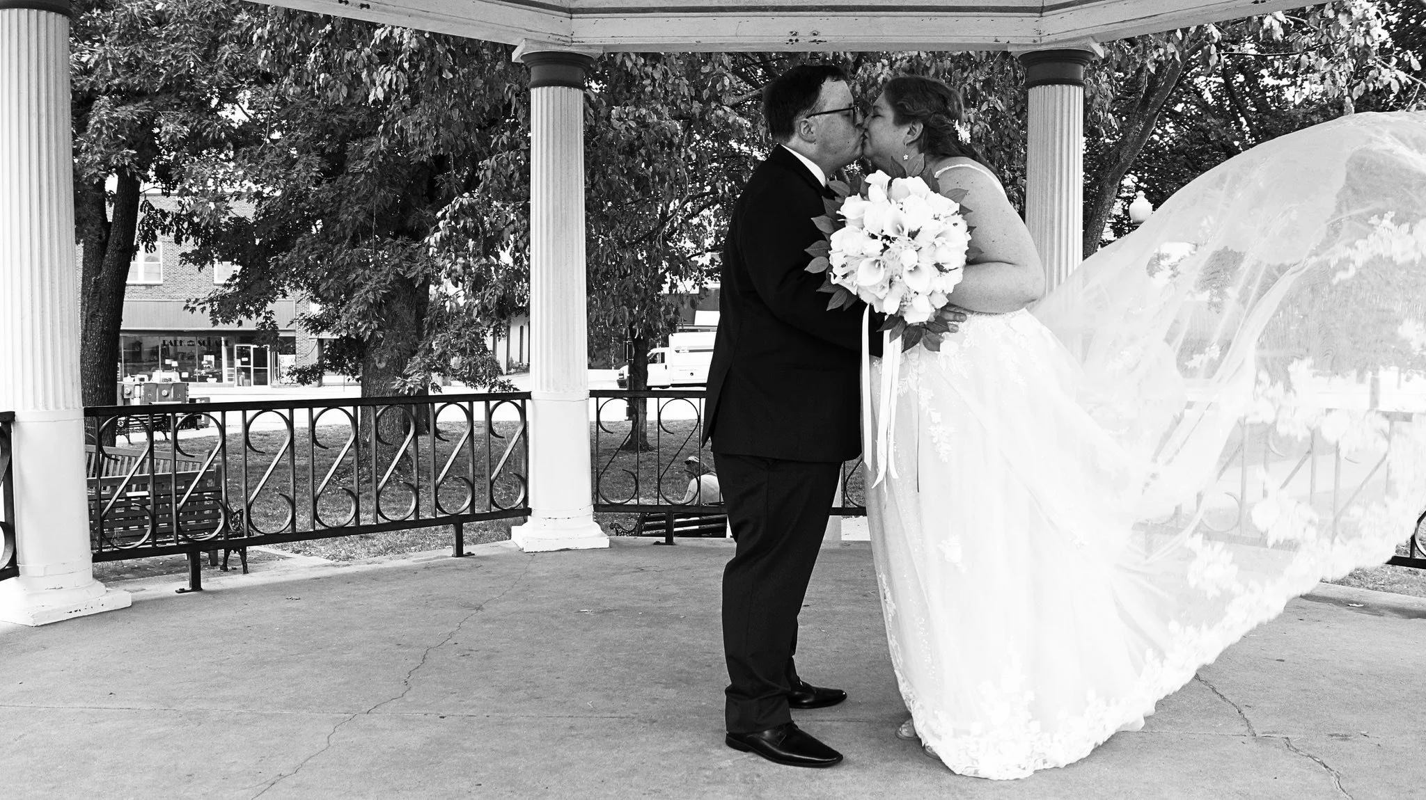 bride-groom-kiss-bouquet-flowing-dress-black-and-white