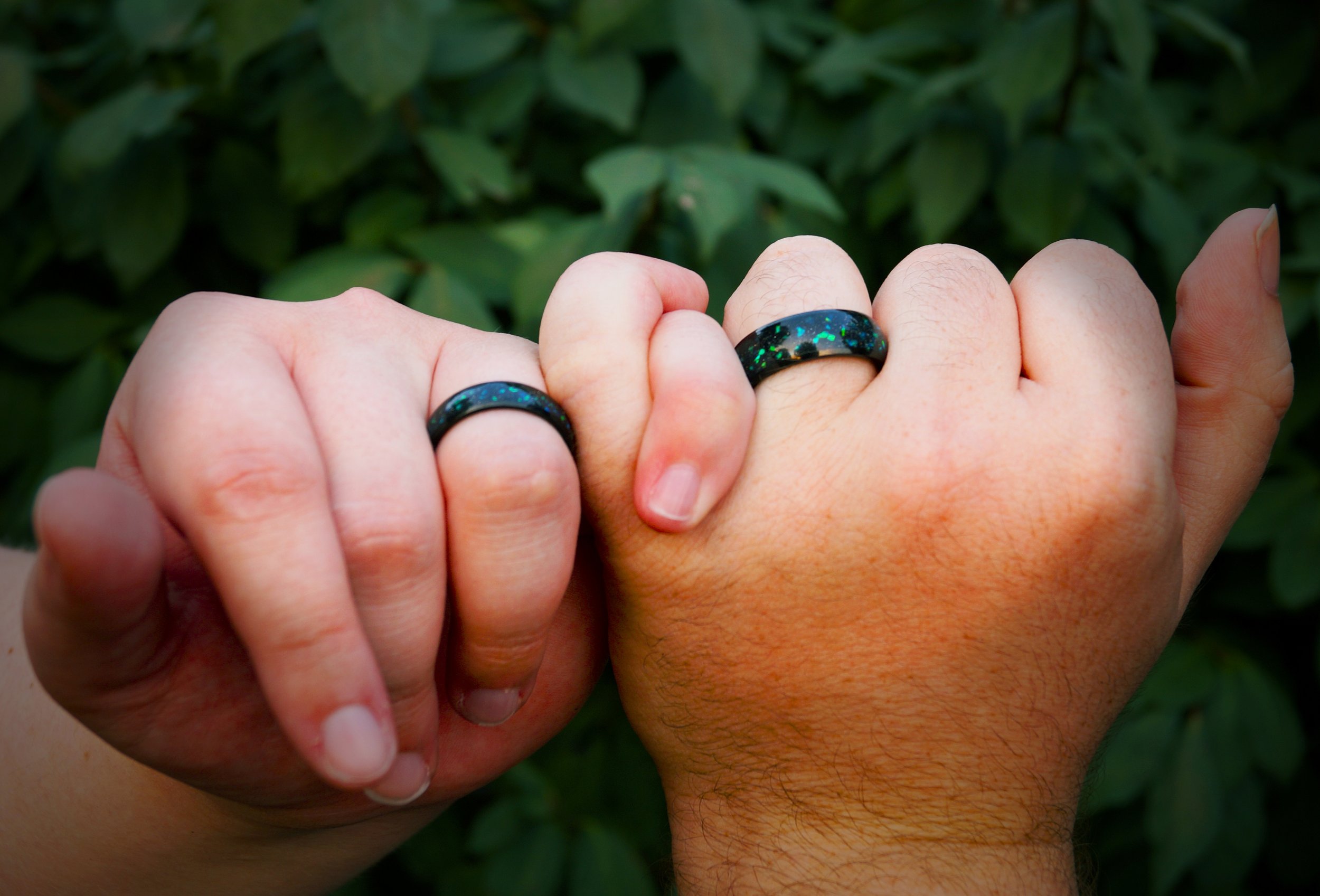 engagement-rings-hands-linked-pinky-holding-hands-greenery