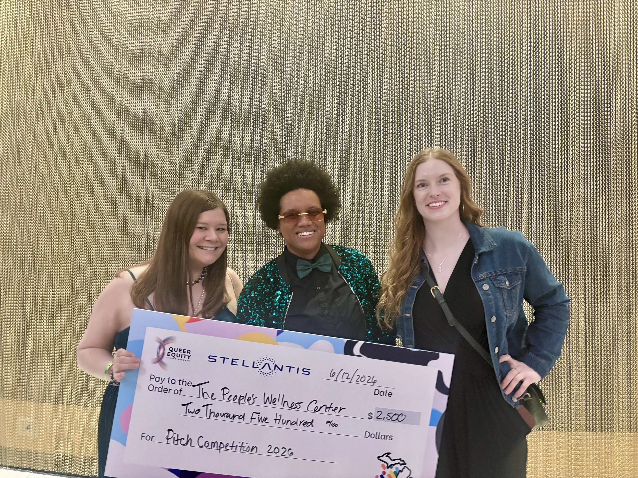 Rachele and Vanessa Rose holding grant check from Stellantis at the Detroit Pride Chamber of Commerce Gala