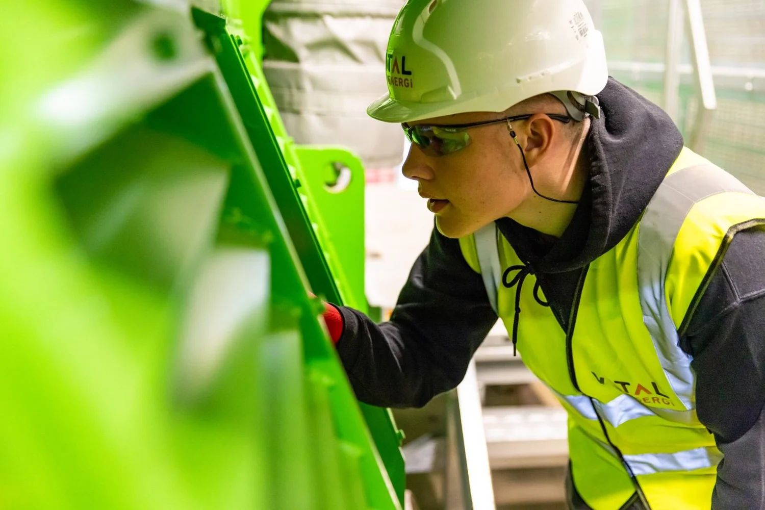 Factory worker inspecting industrial machinery
