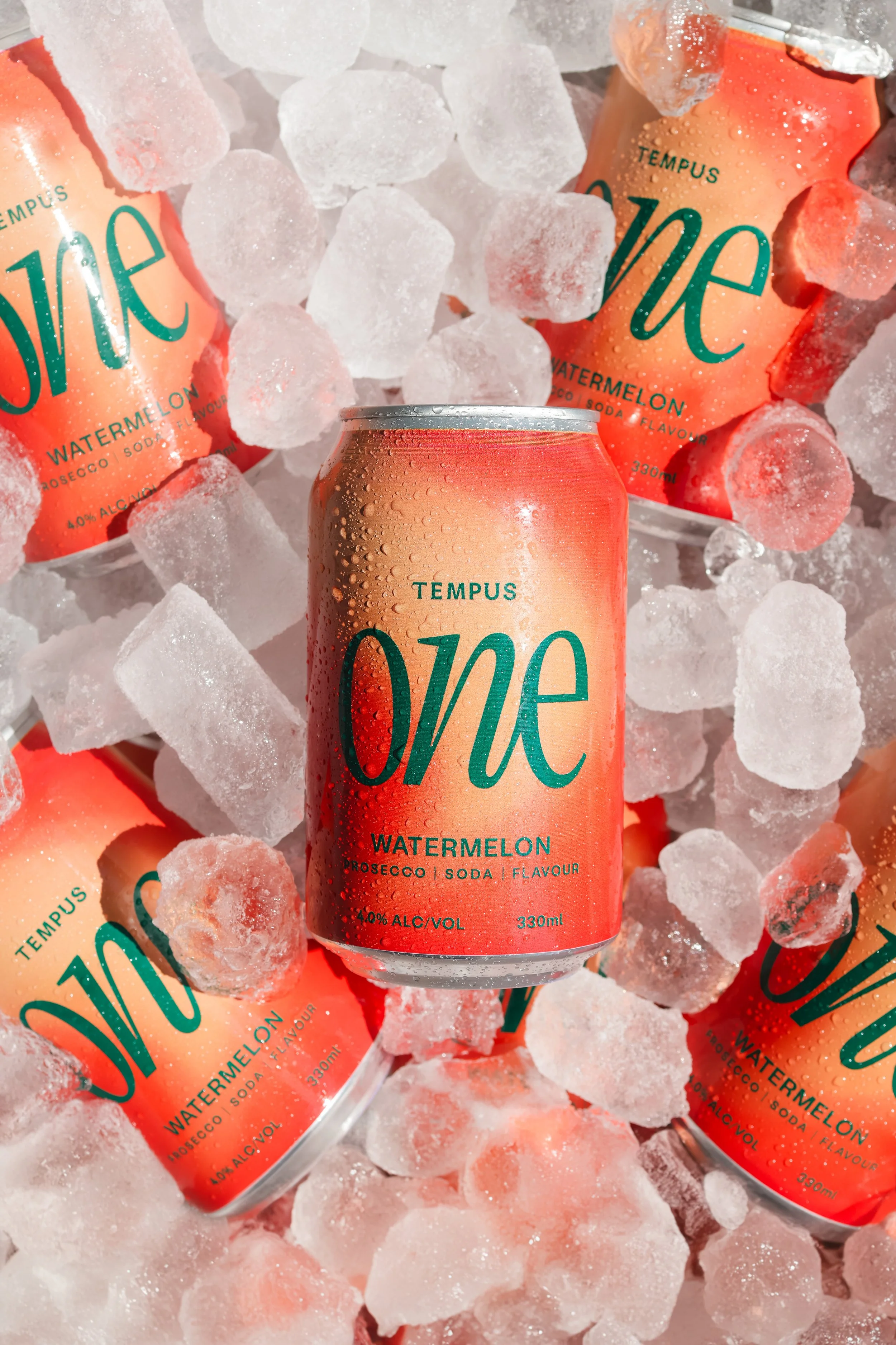 Cans of Tempus Watermelon Prosecco soda on ice cubes.