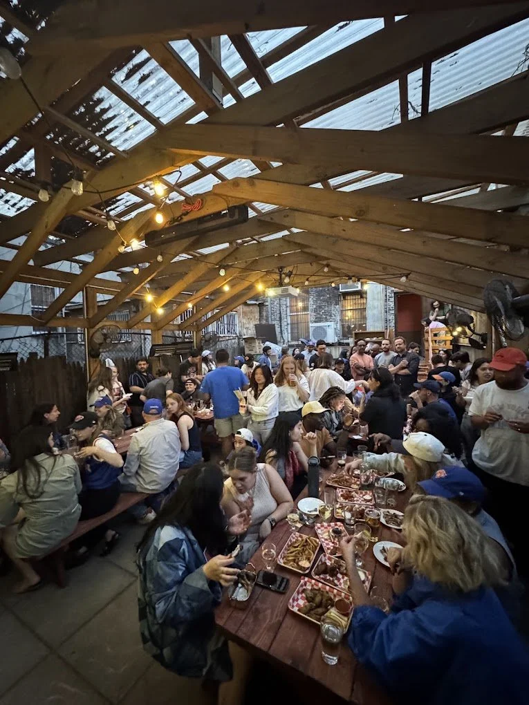 Backyard with humans drinking and eating wings