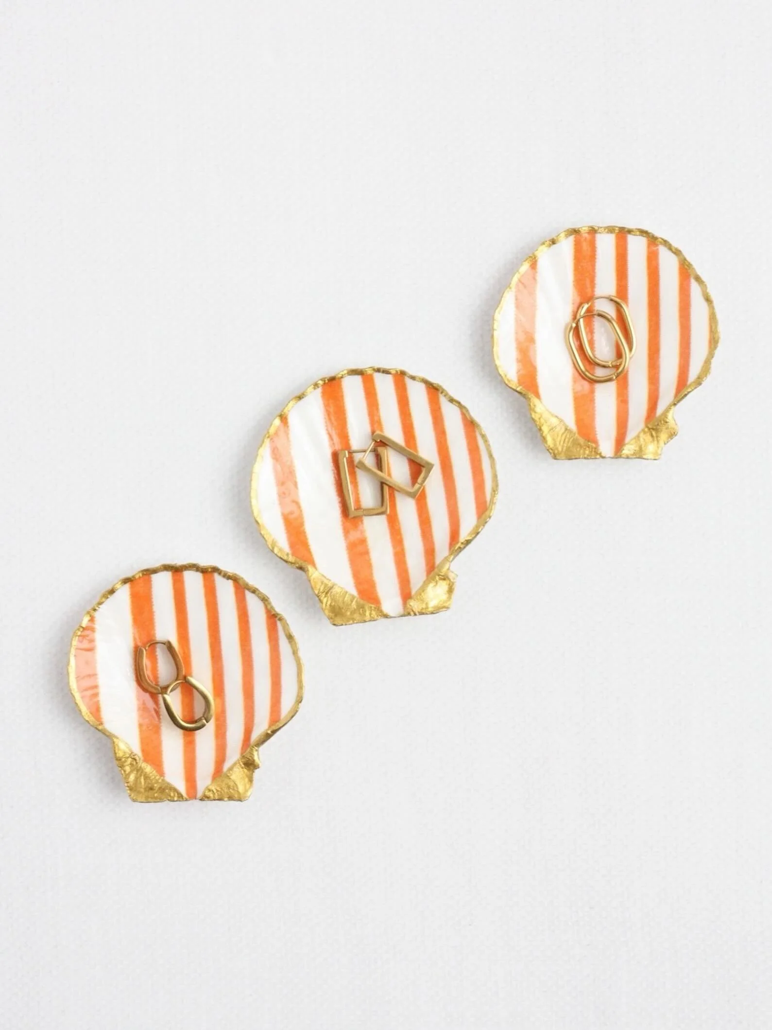 Tiny shells, golden details &amp; a pop of orange 🐚🍊 
Jewelry by @isabelletoledano_jewelry ✨ 
Shop the collection through the link in bio!

#shellringdish #coastaldecor #ateliercoquille
