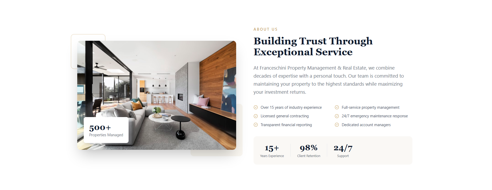 A modern living room with a sectional sofa, coffee table, large windows, and a view of the outdoors, with a kitchen area in the background.