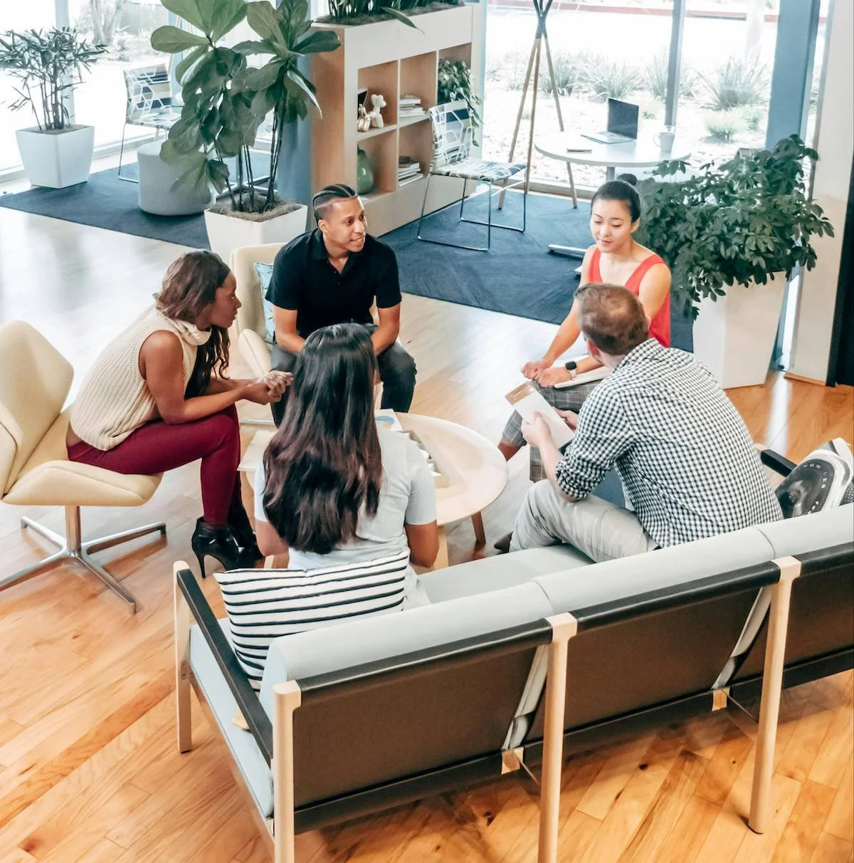 Five people engaged in an open, empathic conversation at a workplace