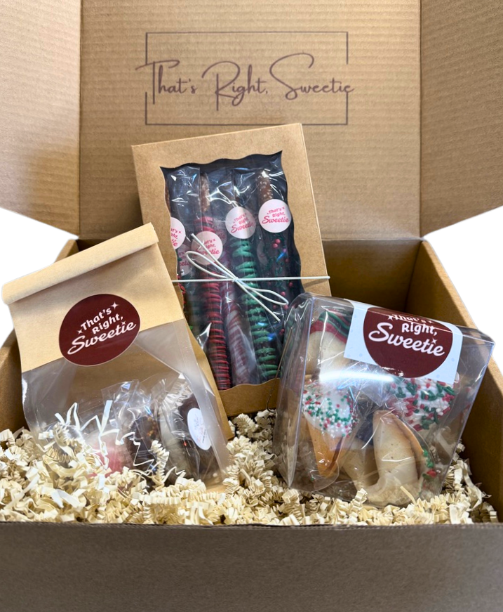 A gift box containing assorted Christmas treats including decorated sugar cookies, wrapped candies, and chocolate-covered pretzels, all labeled 'That's Right, Sweetie'.