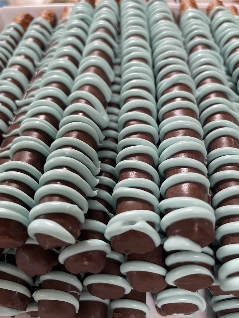 Rows of chocolate bars wrapped with light blue ribbon loops.
