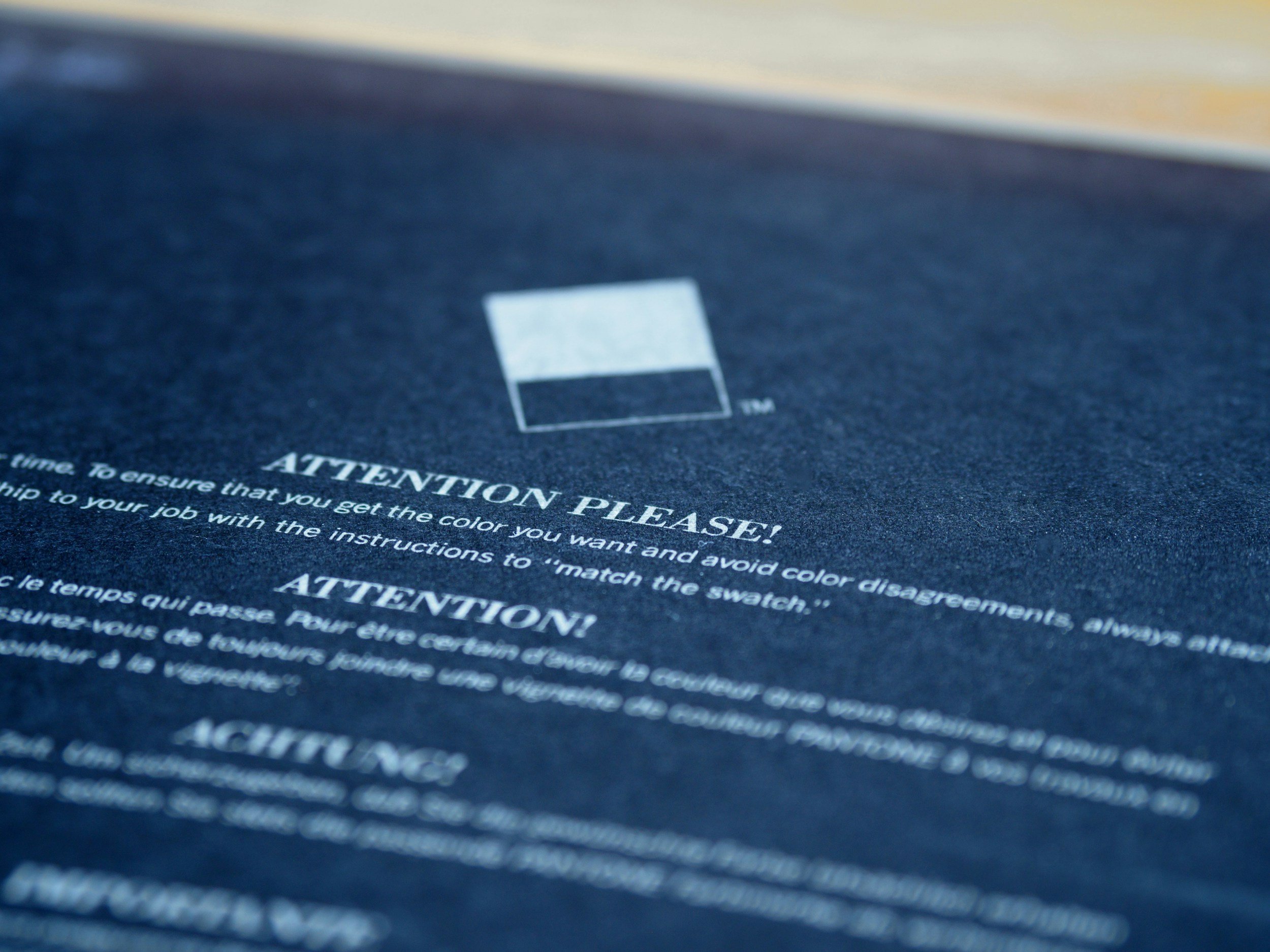 Close-up of a navy blue fabric with white text about matching a swatch, a small square color swatch, and the heading 'Attention Please!'