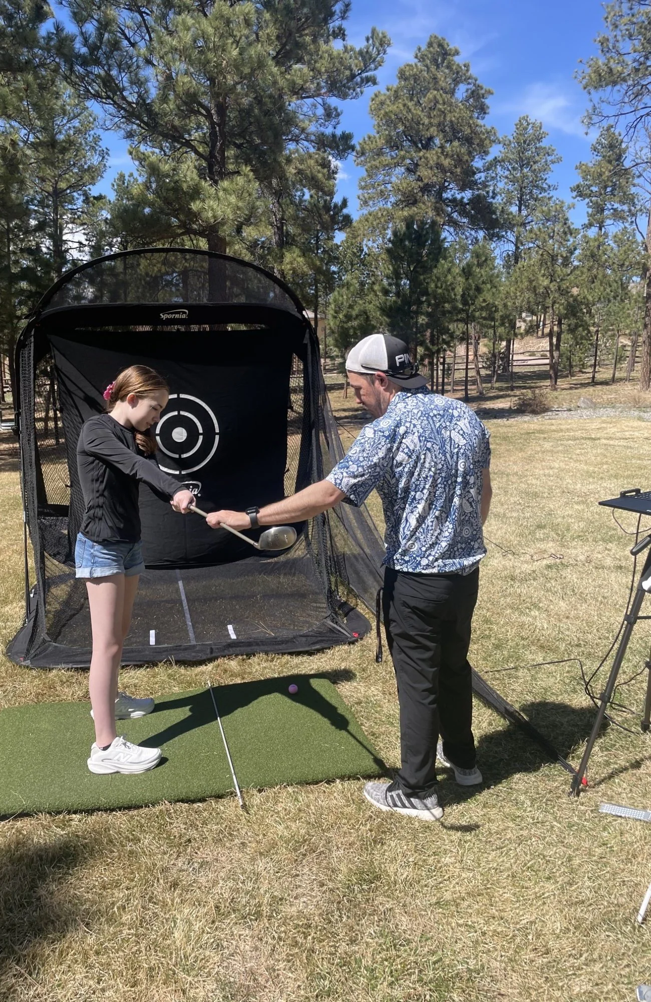 PGA Professional giving outdoor golf lesson to junior golfer in Colorado Springs.