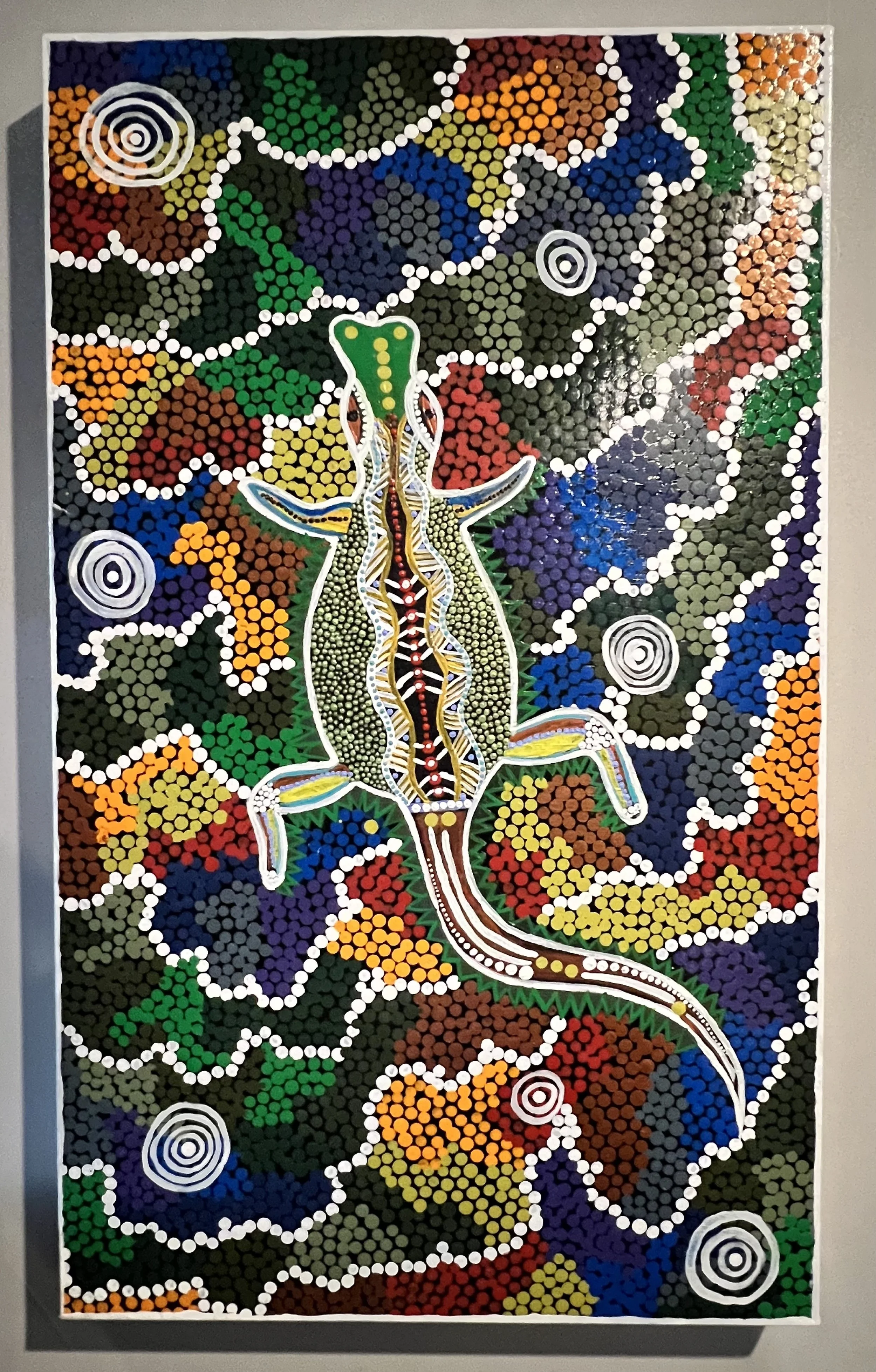 Indigenous Australian dot painting of a yii djamala, a lizard, with vibrant colors and intricate patterns.