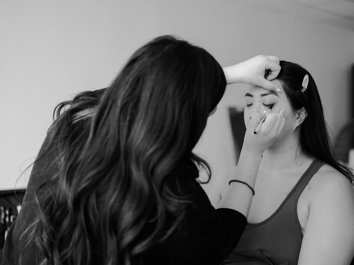 Client having her makeup professionally applied before her boudoir session