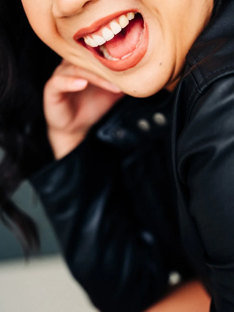 Close-up portrait of a smiling woman wearing a leather jacket