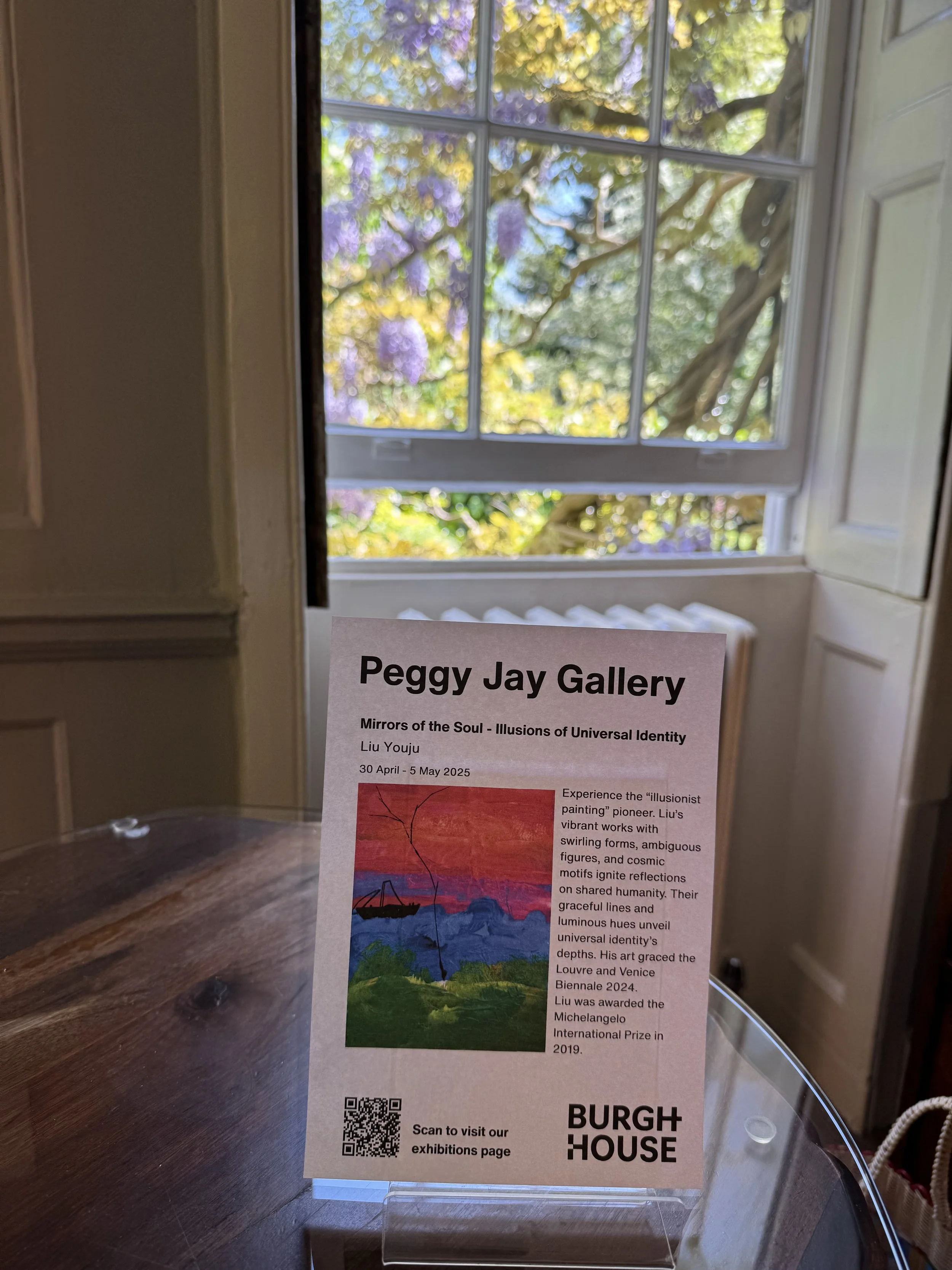 Exhibition information for 'Mirrors of the Soul - Illusions of Universal Identity' by Liu Youju, displayed at Peggy Jay Gallery. The poster features an image of a boat on water at sunset with red, blue, and green colors, and a QR code at the bottom f