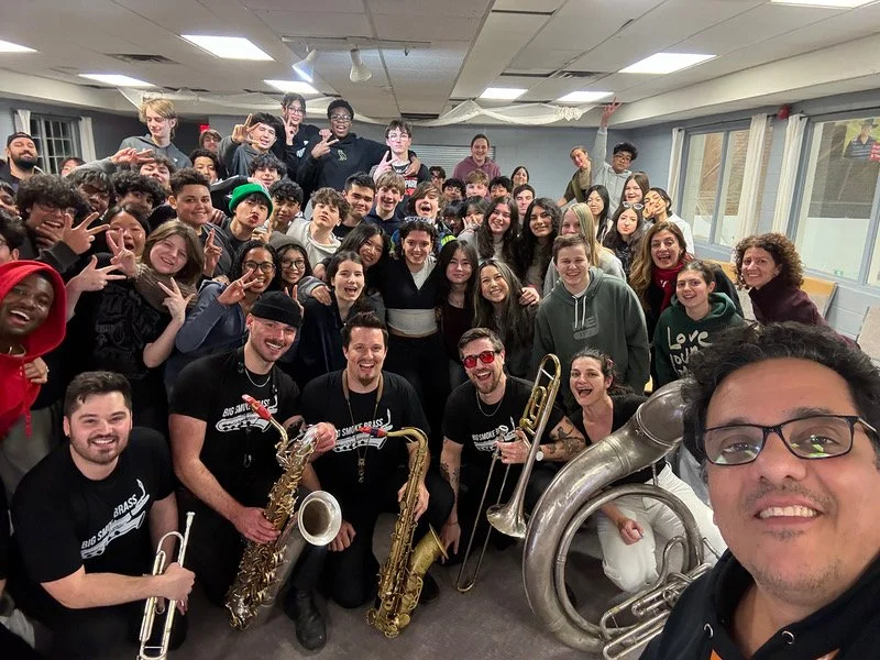 A group photo of Students, Teacher, and the band all smiling after an exciting and engaging clinic.
