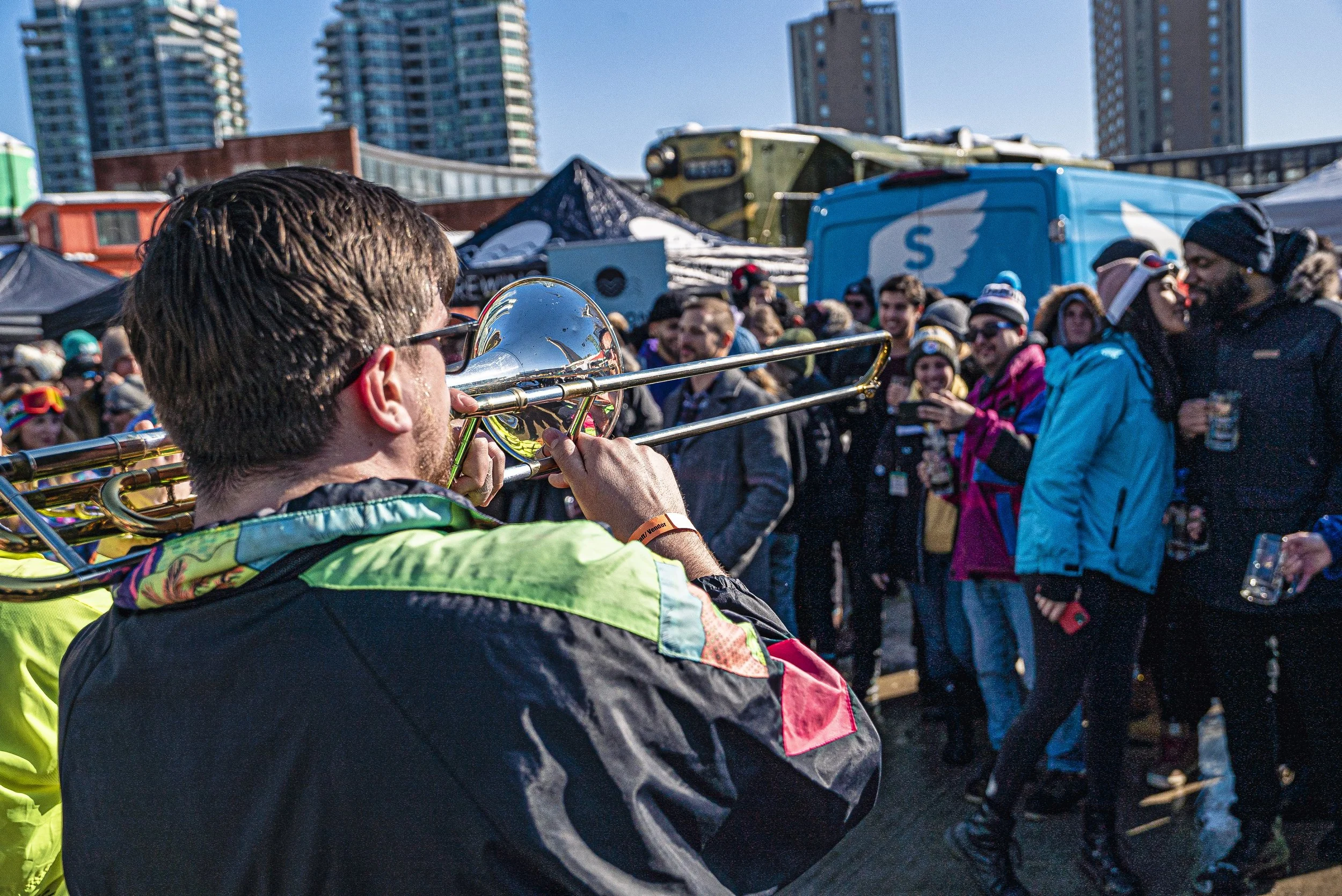 A trombone playing to a crowd of excited festival goers.