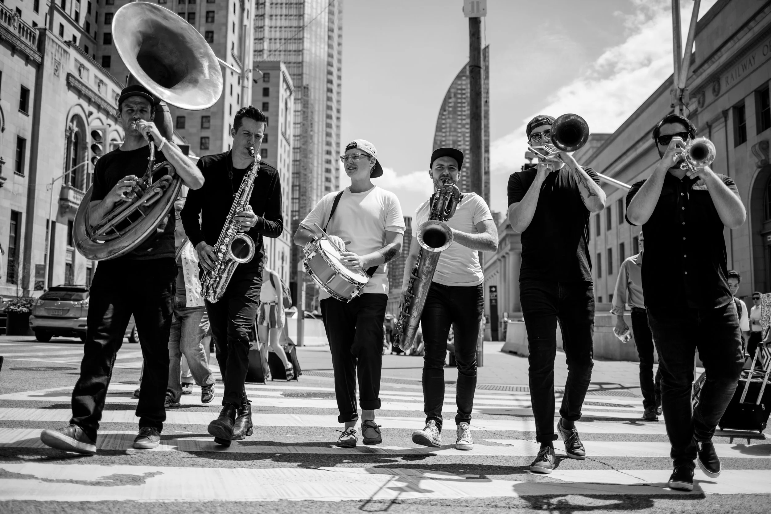 An old photo of Big Smoke Brass playing on the street. This photo pays homage to their busking roots.