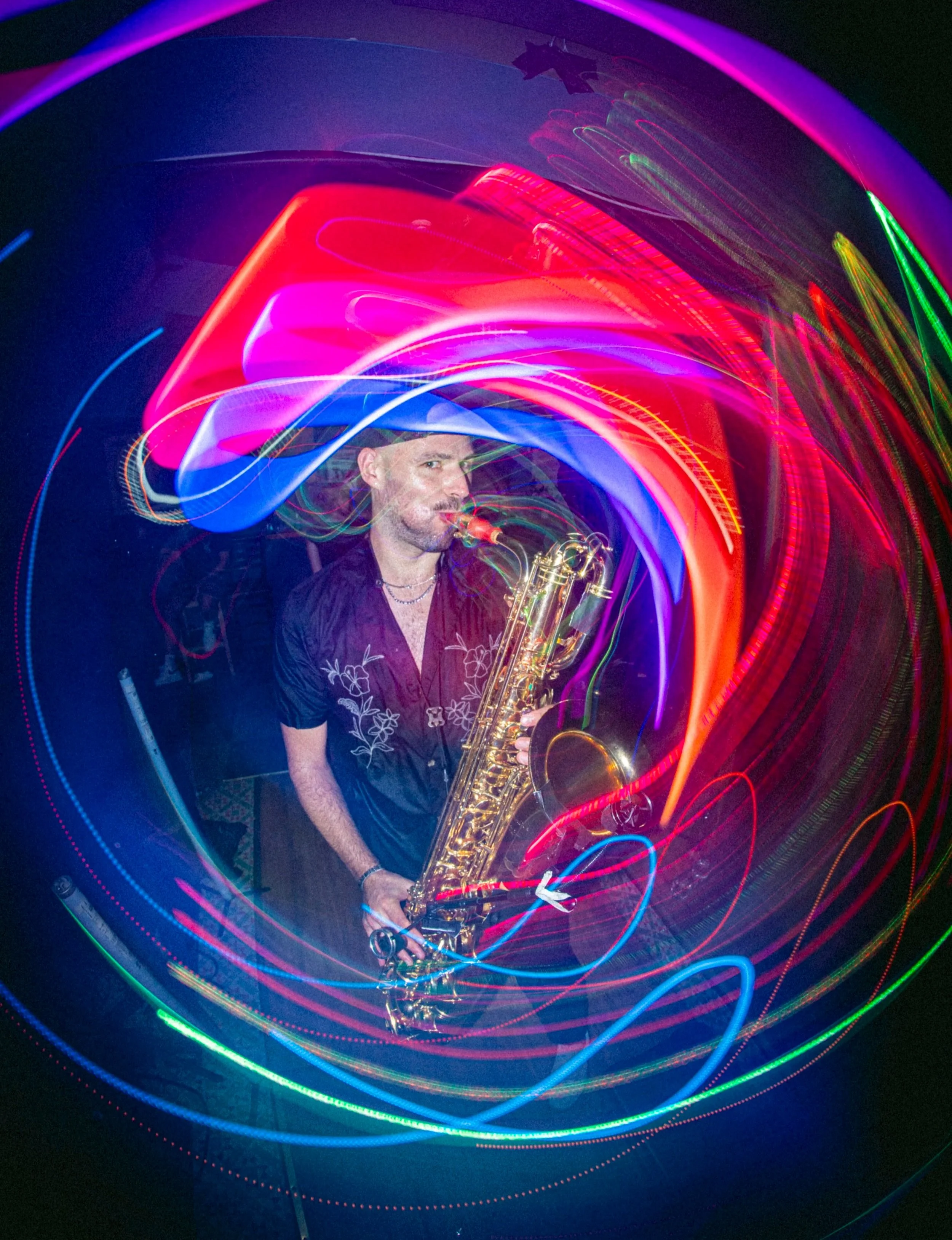 The Baritone Saxophone player playing at one of Toronto's most infamous live event spaces, Drom Taberna. The photo plays with light and show how high energy the band is - lots of movment and exciting visuals.