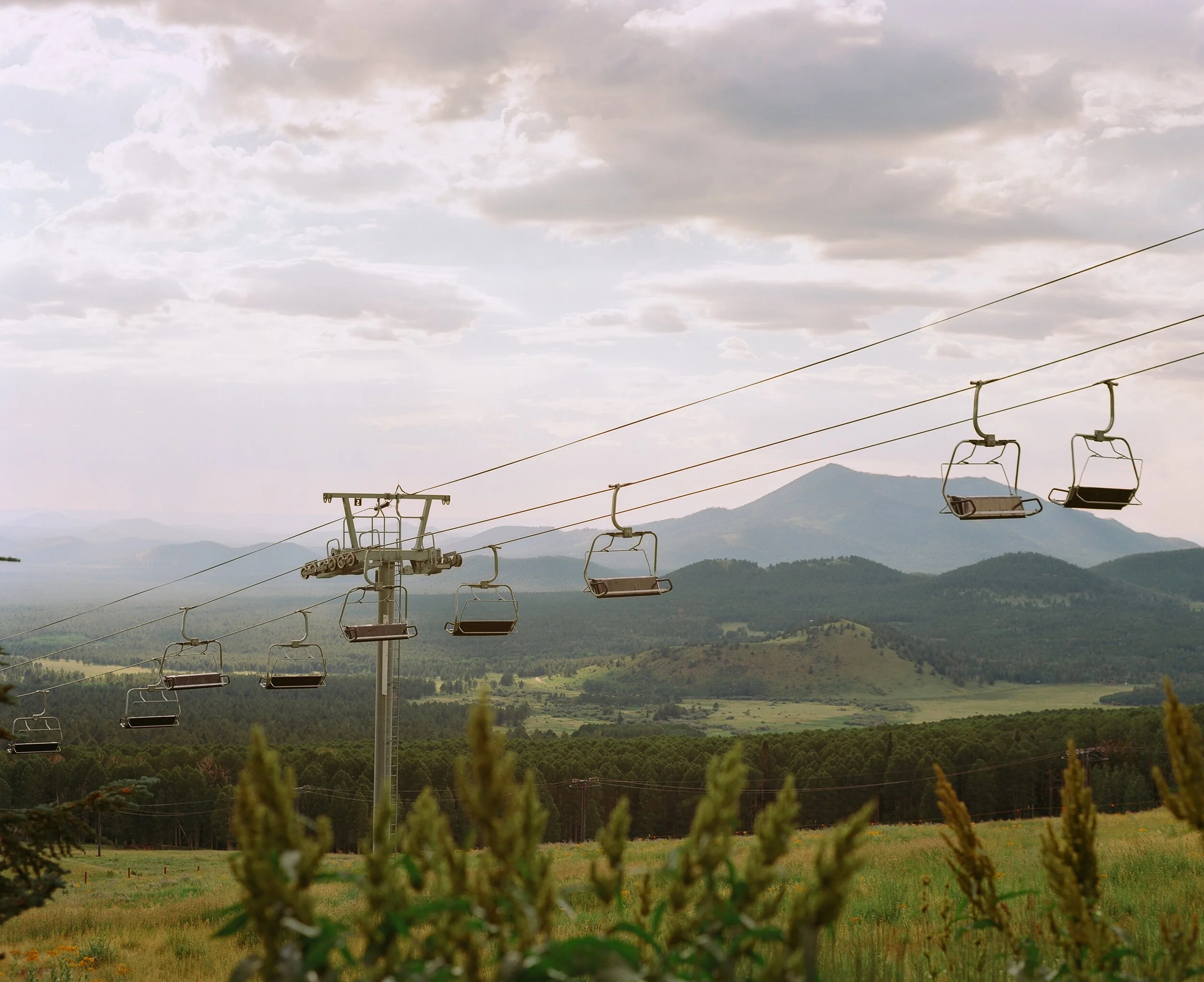 Mountain landscape with cable cars and cloudy sky.
