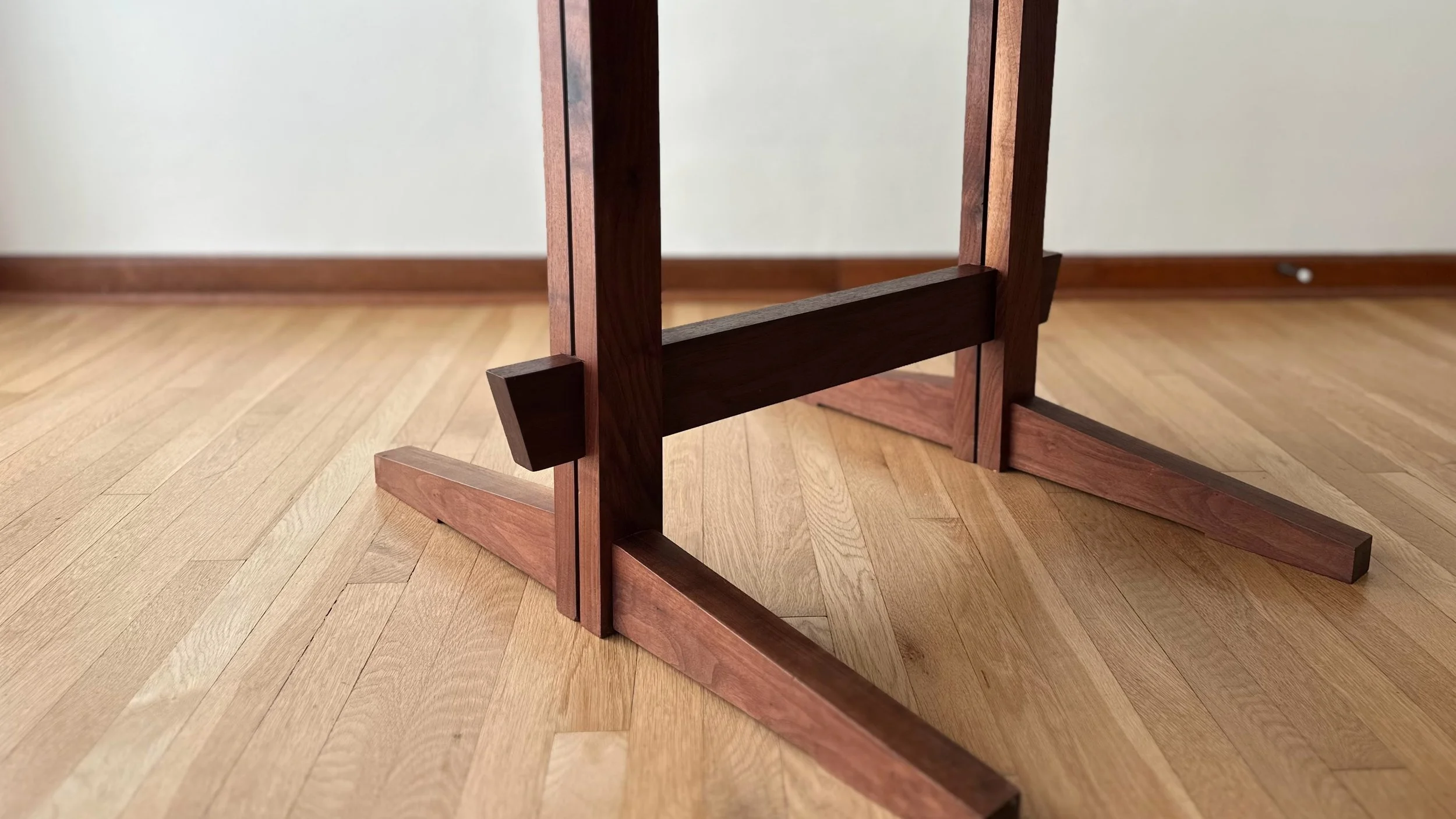 Hand-cut joinery detail on solid walnut trestle table base