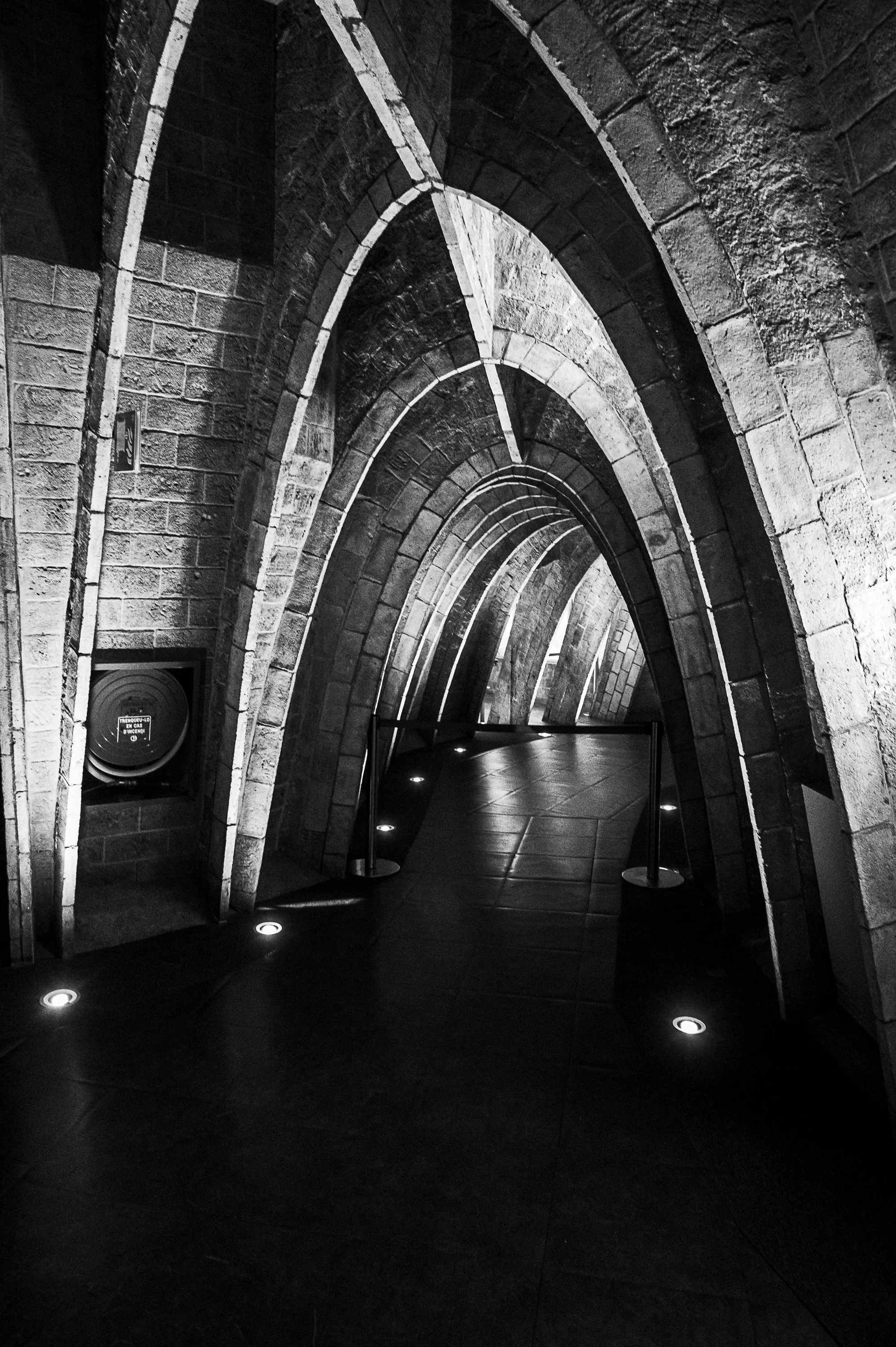 Repeating stone arches lead through a vaulted passage inside Casa Milà in Barcelona.