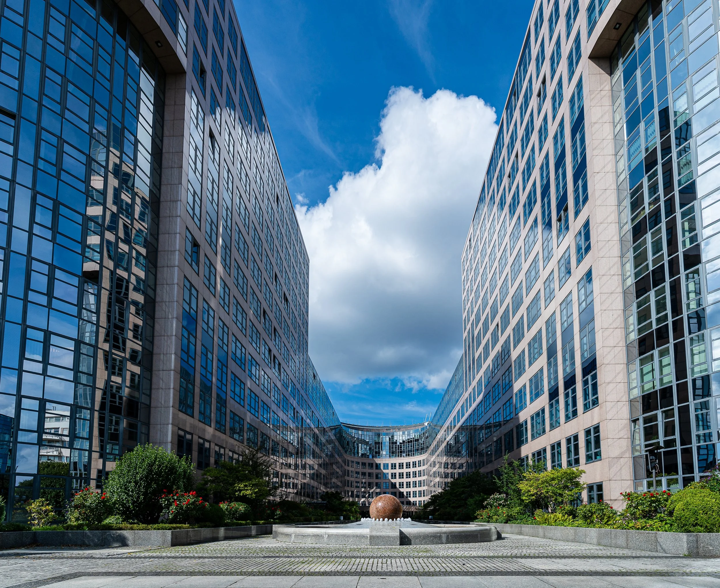 Modern architecture beneath moving clouds