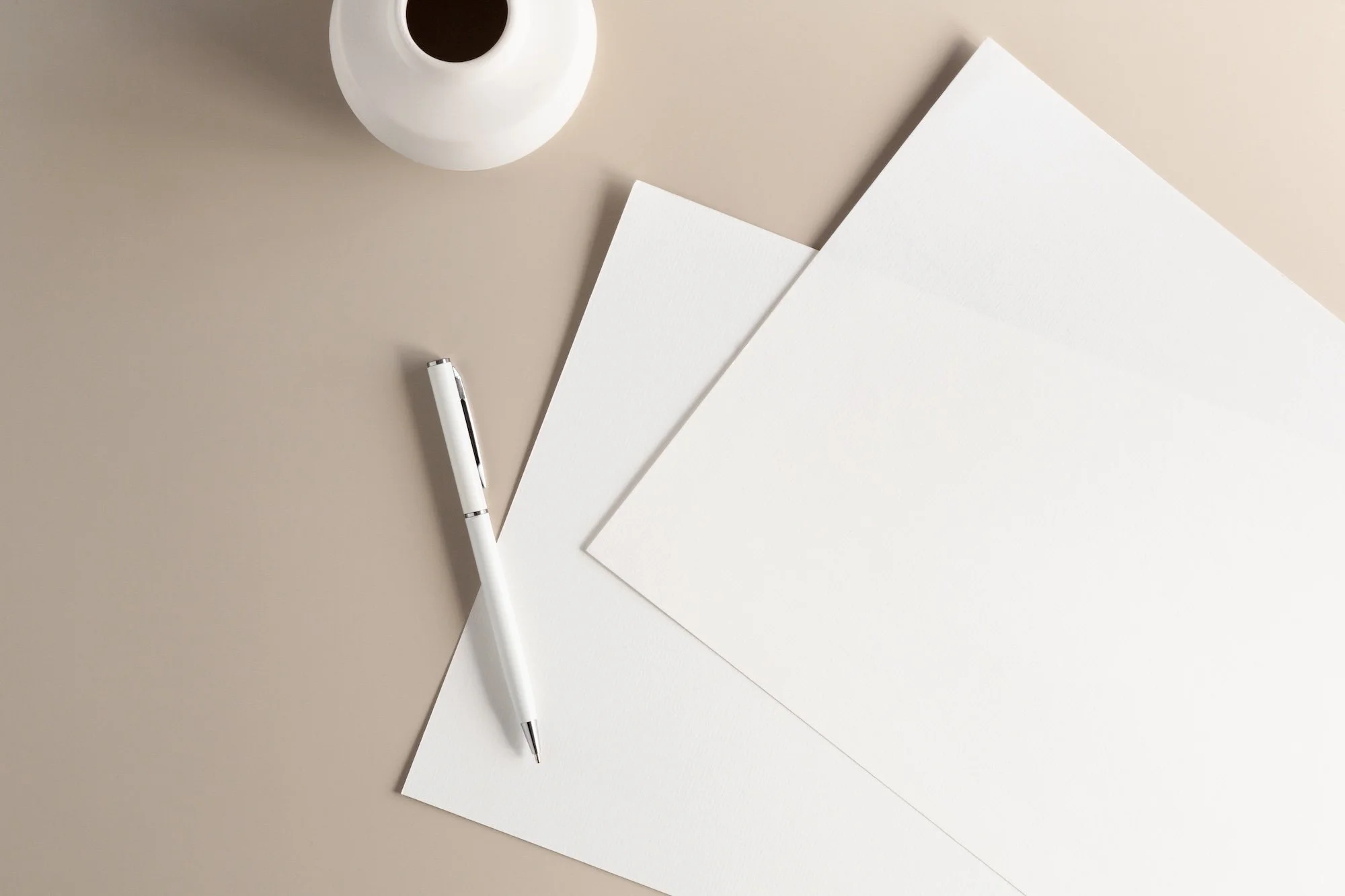 Papers and pen on a beige background