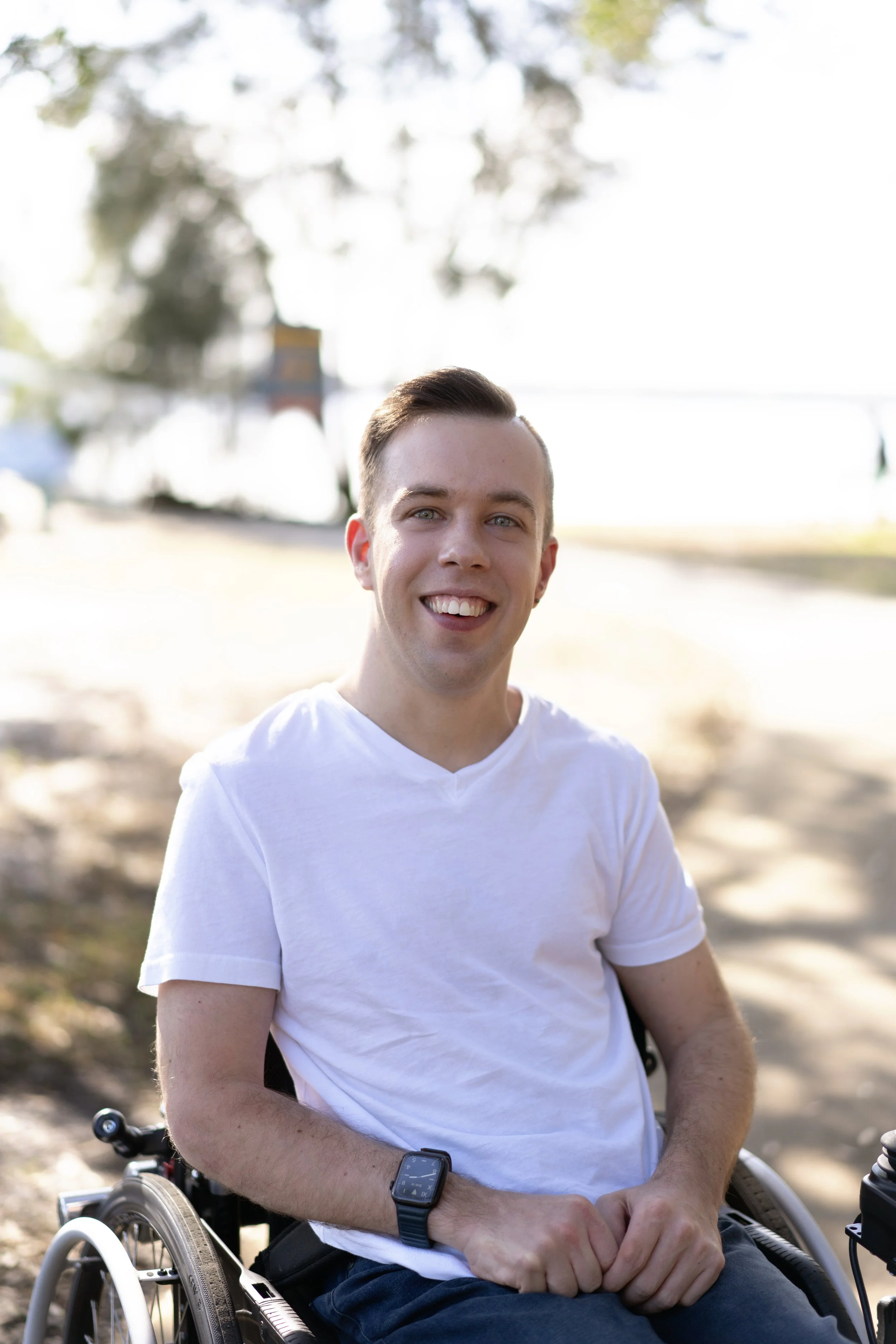 Aaron Millerand, social worker and disability support provider, founder of Breaking Limits, smiling outdoors in a wheelchair.