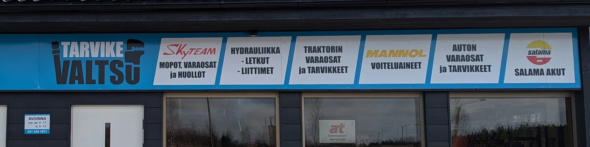 Tarvike valtsun liikkeen kylttejä pääsisäänkäynnin yläpuolella