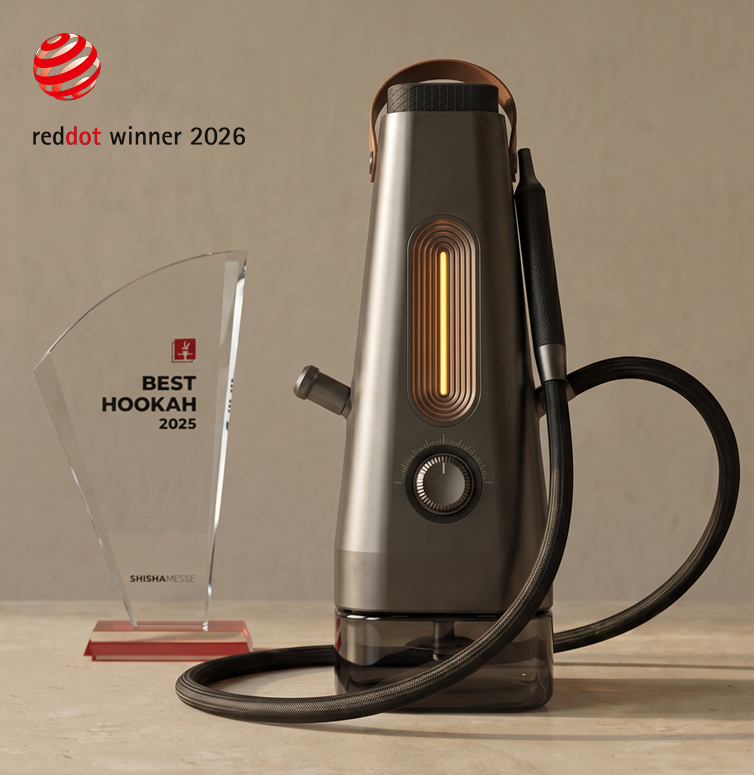 A modern vaporizer device with a glowing orange line and control dial, placed on a light-colored surface. Next to it is a trophy with the text 'Best Hookah 2025' and a red emblem, and a 'Red Dot Winner 2026' logo in the top left corner.