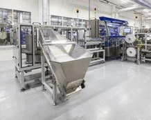 Industrielle Produktionsanlage mit Förderband und Maschinen in einer Fabrikhalle