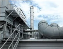 Industrielle Anlage mit Tanks, Rohren und Schornstein unter blauem Himmel