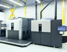 Drei große industrielle 3D-Drucker in einem Fertigungsraum.