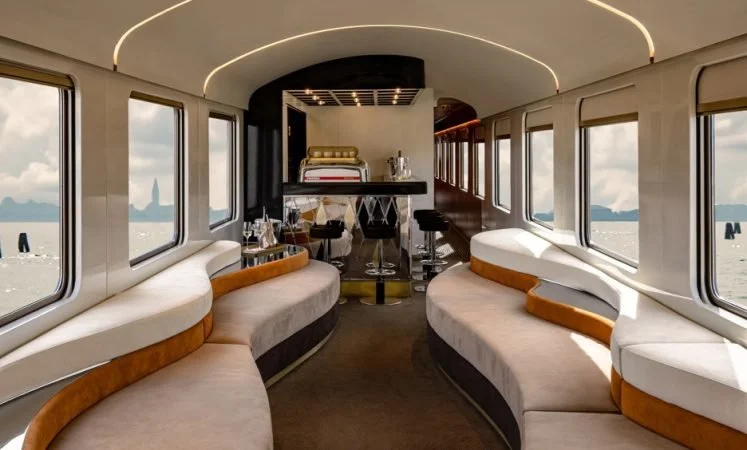 Five-star dining car on a luxury European train featuring white tablecloths and mountain views