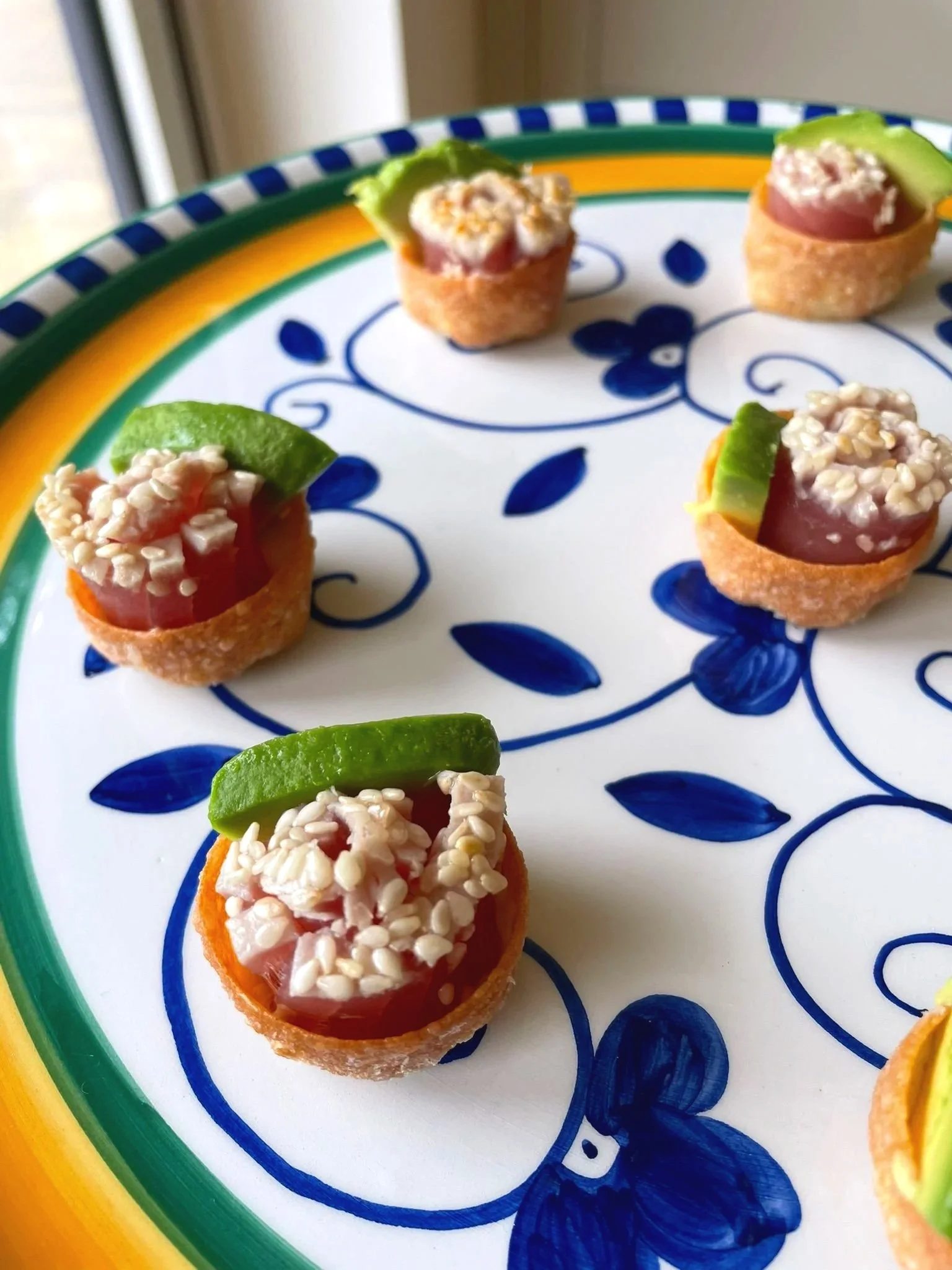 Five pieces of snack cups with cherry tomatoes, cucumber slices, and rice on a decorative plate.