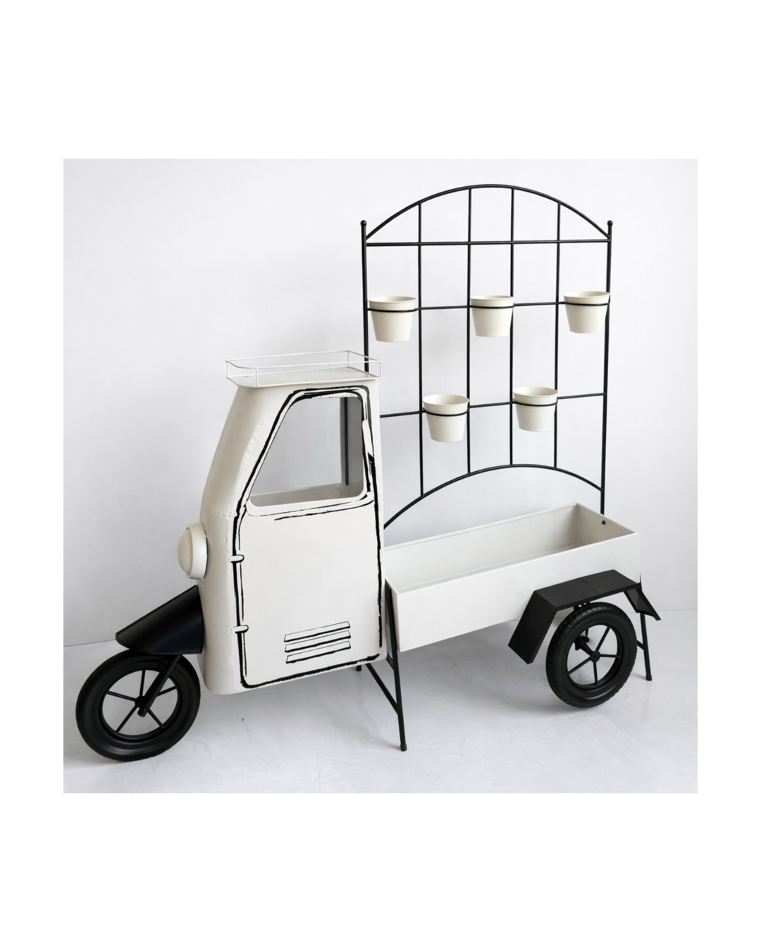 Decorative black and white vintage-style tri-wheel cart with a box at the front, a metal rack with six small white flower pots on a black framework, and an area for storage or display.