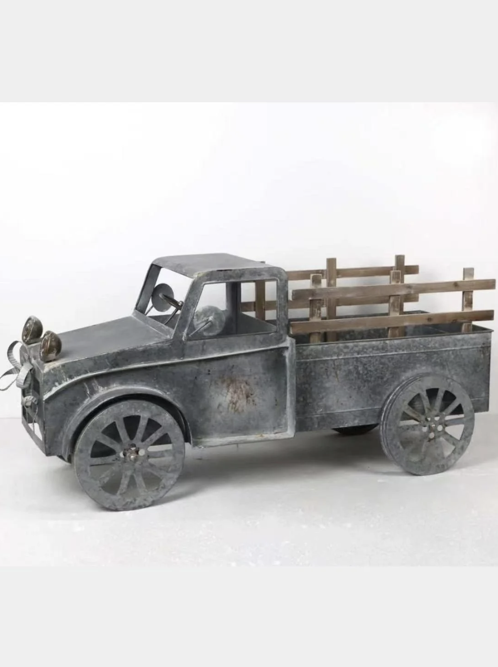 Metal decorative truck with wooden bed, designed to look vintage or rustic.