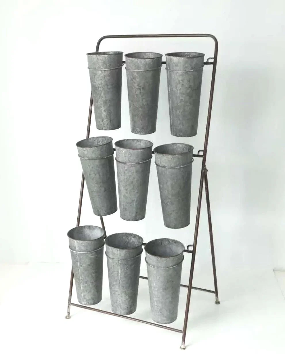 Metal buckets stored on a metal rack against a white background.
