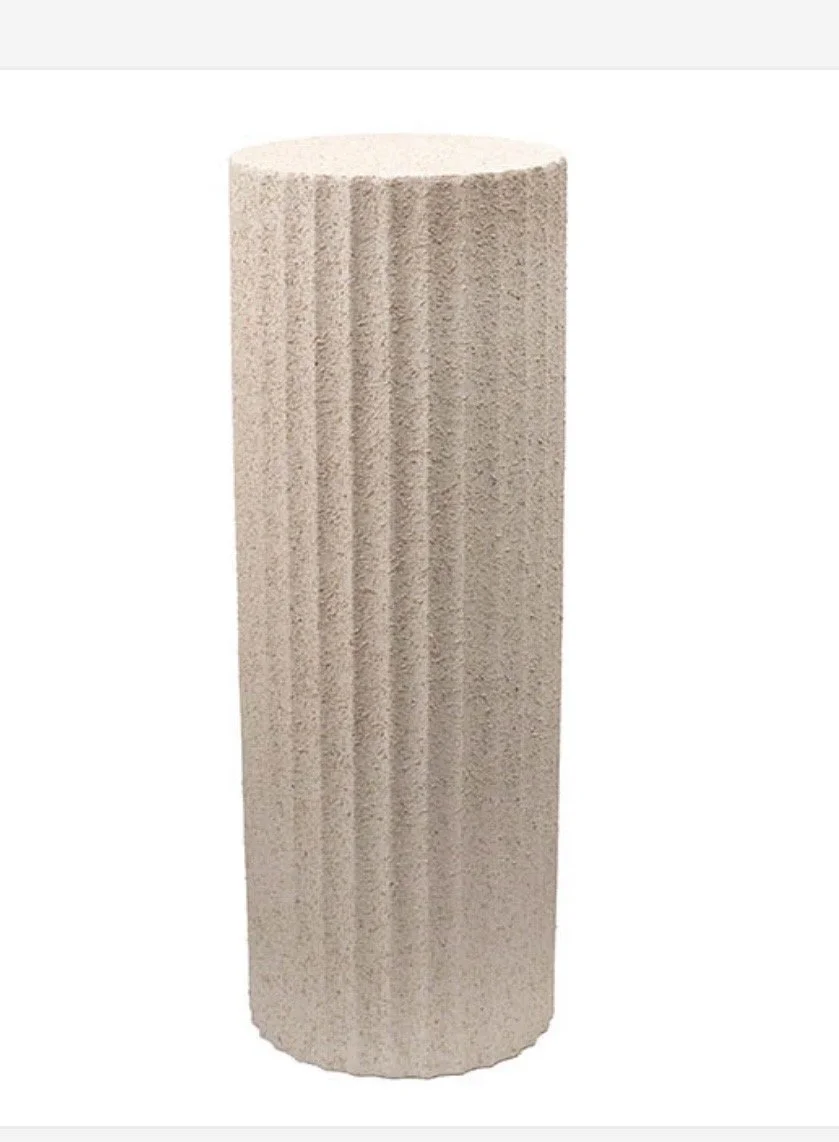 Beige cylindrical object with vertical grooves, resembling a textured column or pillar.