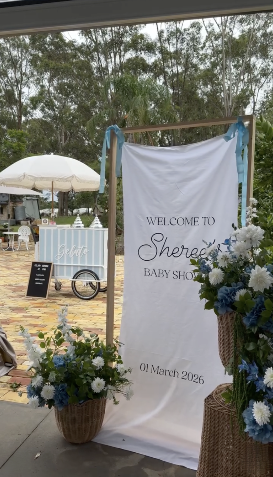 Welcome sign for Sherese's baby shower with flowers and date, March 1, 2026, in an outdoor setting