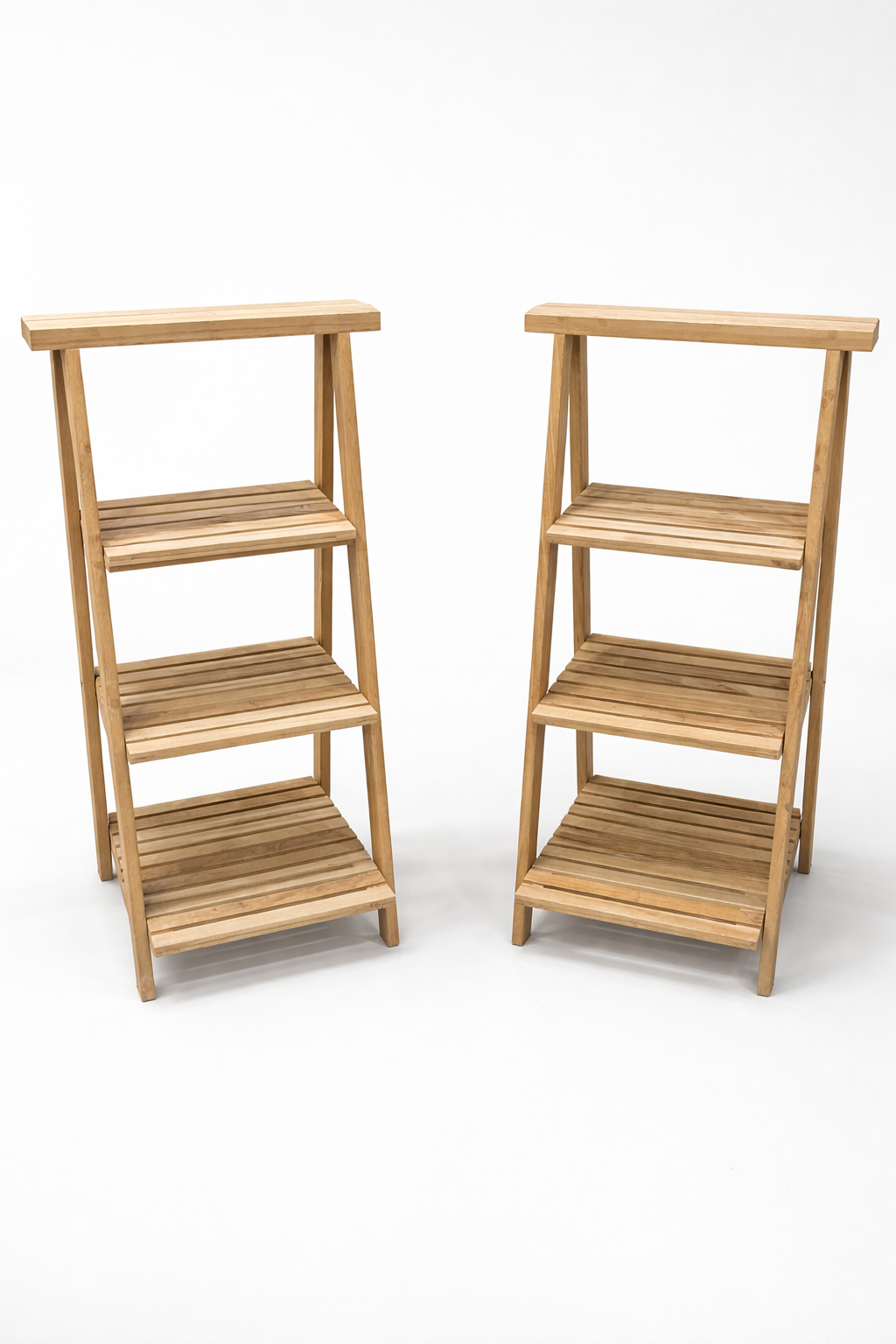 Two wooden tiered plant stands with three shelves each, set against a white background.